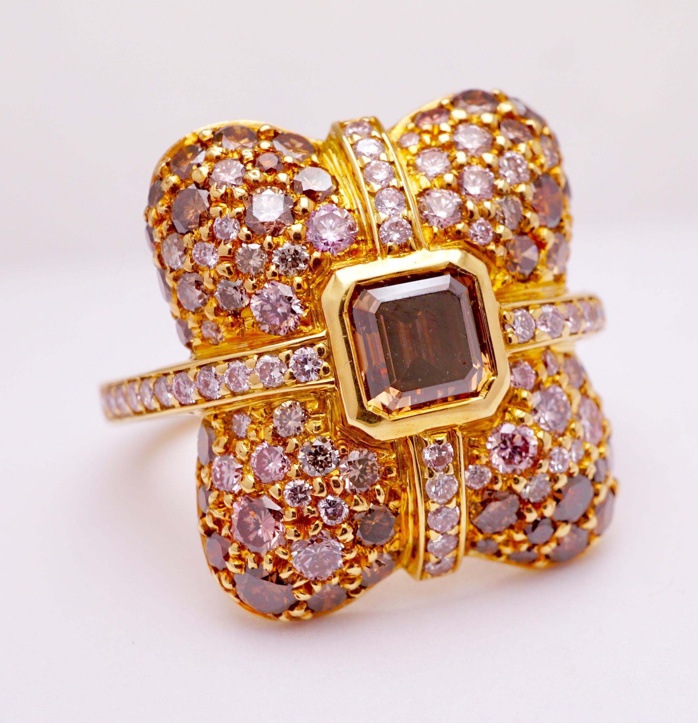 Diamond Ring with cross band of Pink pave set Diamonds, center stone is .90ct Asscher cut Orange-Brown VS2 Emerald cut diamond and graduating Pink, Brown, Orange, Yellow and White Fancy colored VVS-SI1 diamonds, total of 4.56cts. Set in 18K Yellow
