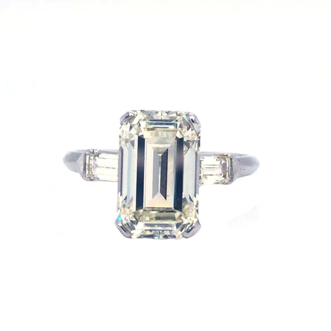 Classic Platinum Diamond ring 4.57 Carat center Emerald Cut Diamond   L - Color, VS1  Clarity, 11.91mm-7.52mm-5.44mm and accented by two Emerald cut diamonds, Totaling 0.56 carat J color, VS1 - Clarity, The ring weighs 4.5 grams, and is currently