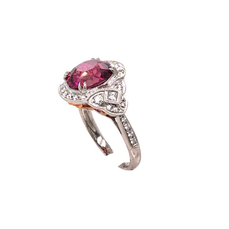 Center: 4.59 Carat Oval Cut Exotic Garnet
Diamonds: 0.45 Carats
Hand engraved milgrain work throughout, including a flair of yellow gold in the under gallery
Ring size 6.25, but can be sized up or down to your specification at no charge.