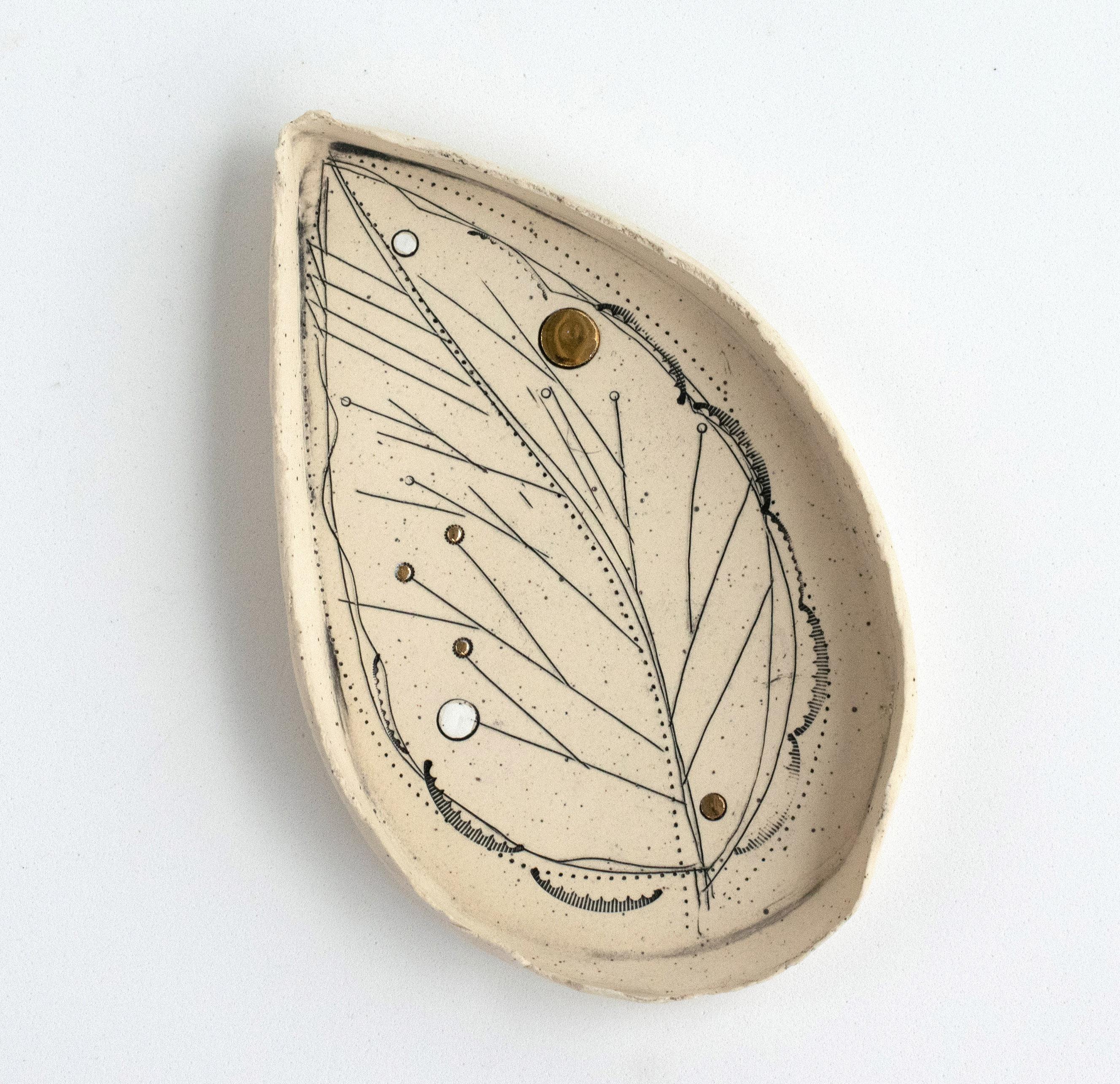  459-G Hand Crafted Golden Promise Leaf Dish With 22kt Gold Detail by Helen Prior

A delicate hand-crafted dish, organic in shape with a torn clay edge in natural speckled stoneware clay.
Part of the Golden Promise Series-  a theme of abstracted and