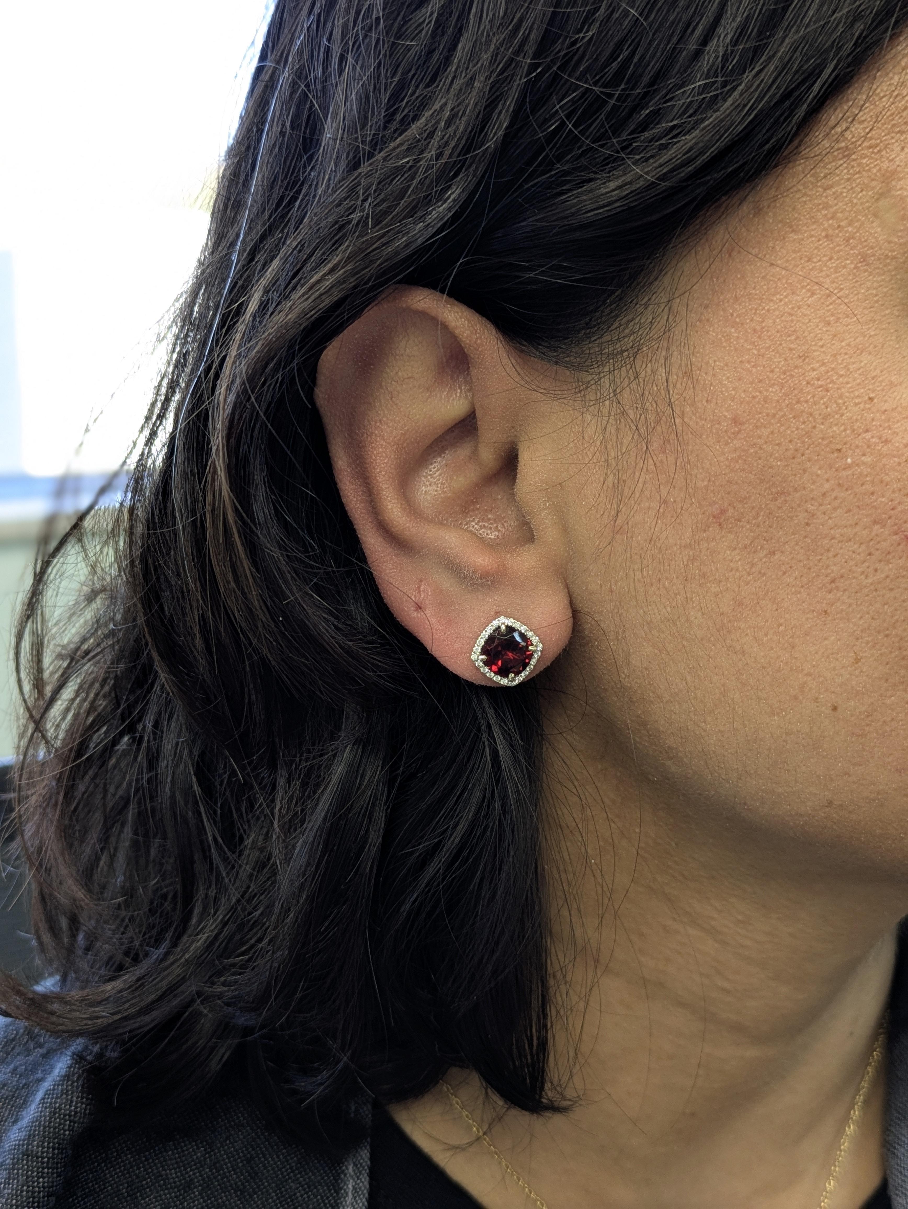 Ces clous d'oreilles en grenat de 4,5ct volent la vedette avec un élégant halo de diamants naturels en or blanc 14k. Un duo saisissant de 8 mm qui allie une couleur ardente à un éclat intemporel.

