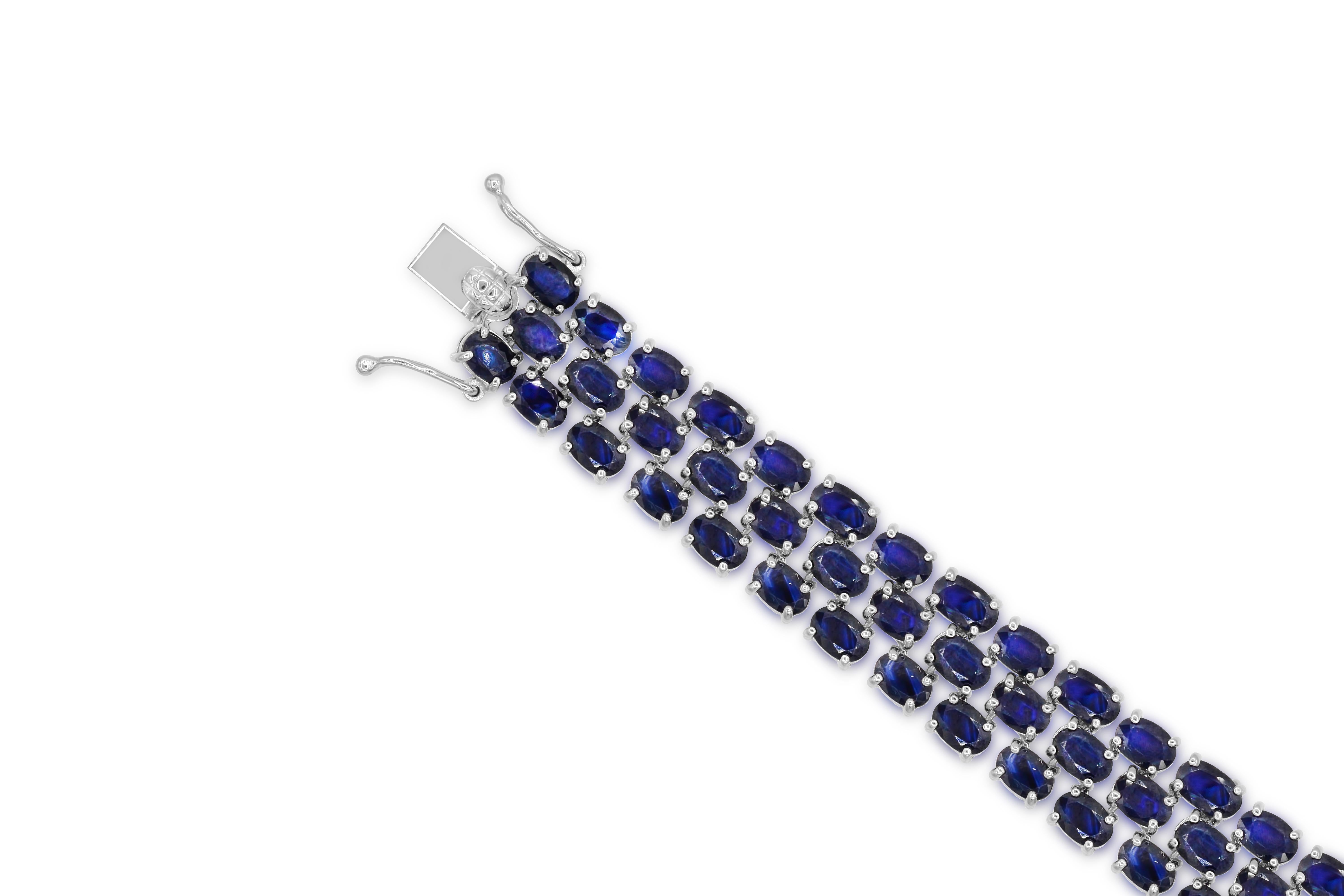 Indulge in the elegance of our 46-1/5 Carat Oval Genuine Sapphire Tennis Bracelet in Sterling Silver. Crafted with meticulous attention to detail, this bracelet boasts a stunning style of 77 oval genuine sapphire gemstones. The silver tone prong