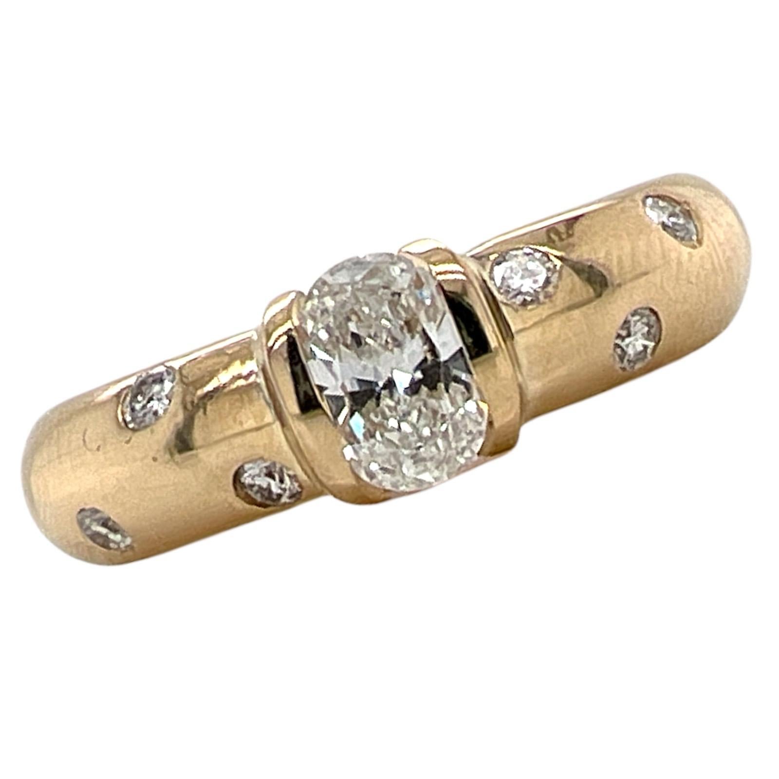 Beautiful oval diamond band ring fashioned in 14 karat yellow gold. The ring features an .46 carat oval diamond graded G color and VS2 clarity by the GIA. The etoile band features another 6 round brilliant cut diamond accents. The band measures 5mm