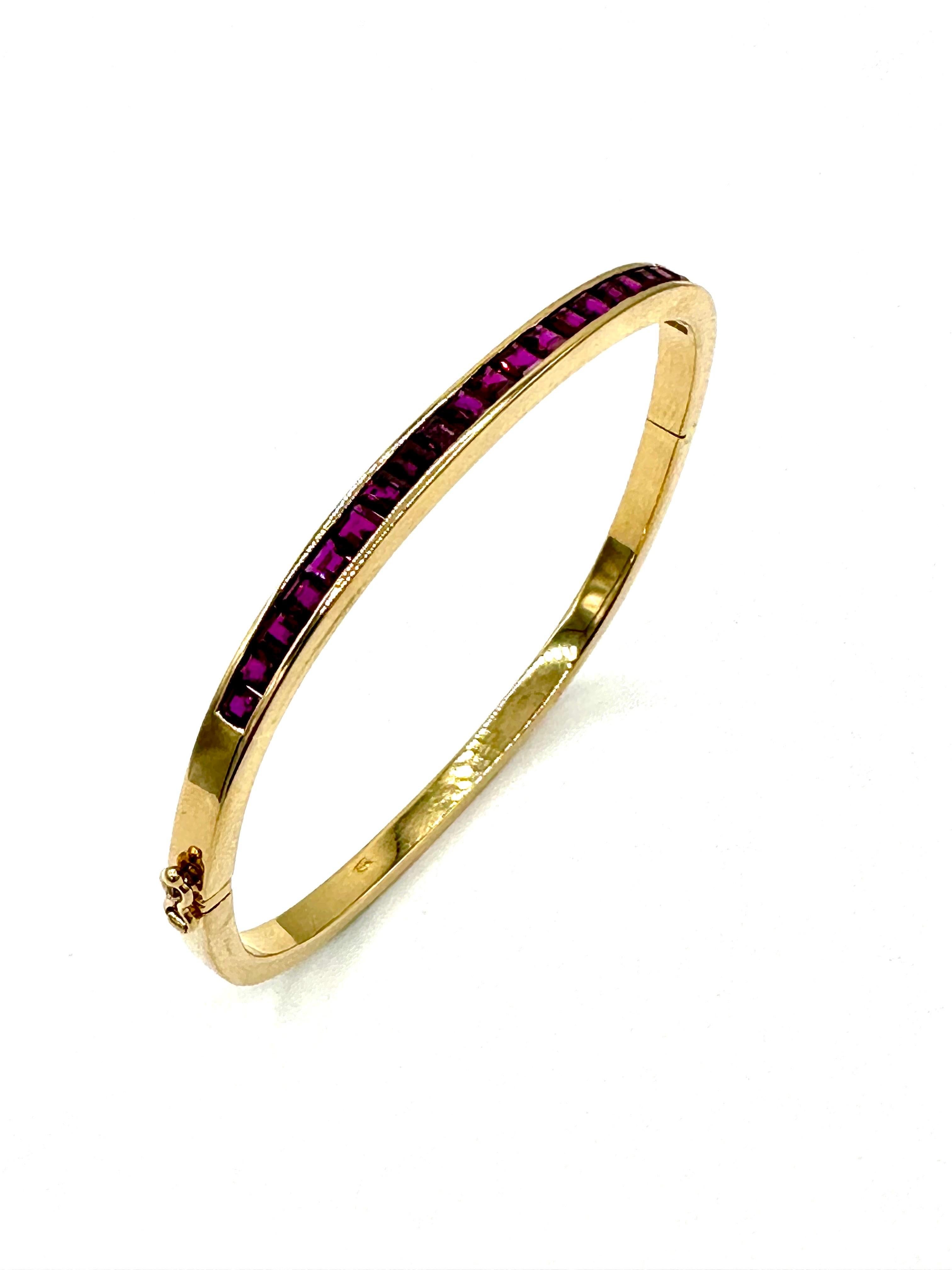 This is a very uniquely designed bracelet, set with 24 square cut Rubies, channel set in the top portion of the bangle bracelet.  The bracelet itself it fashioned in a cushion shape fit around the wrist, and has a hinged opening with a hidden clasp