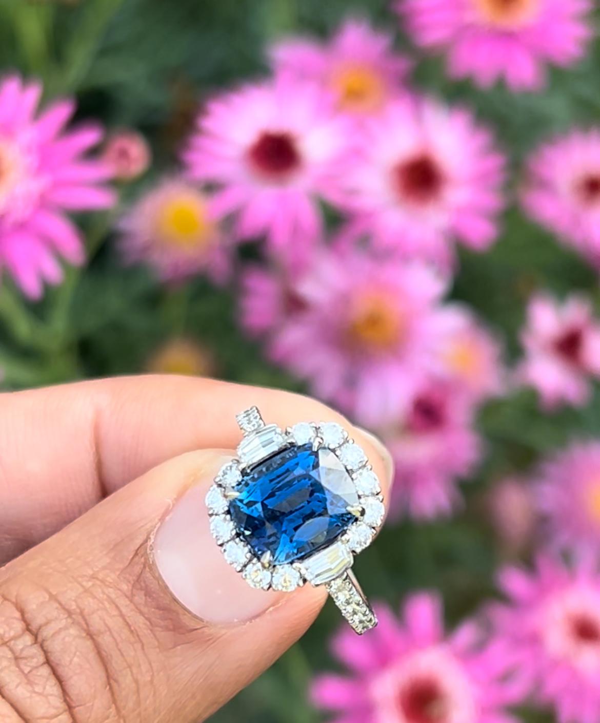 This striking 4.61-carat, untreated cushion-cut GIA certified, Ceylon Sapphire is set between two cadillac-cut and numerous round diamonds in gleaming platinum.

The captivating sapphire displays a beautiful classic blue color which is completely