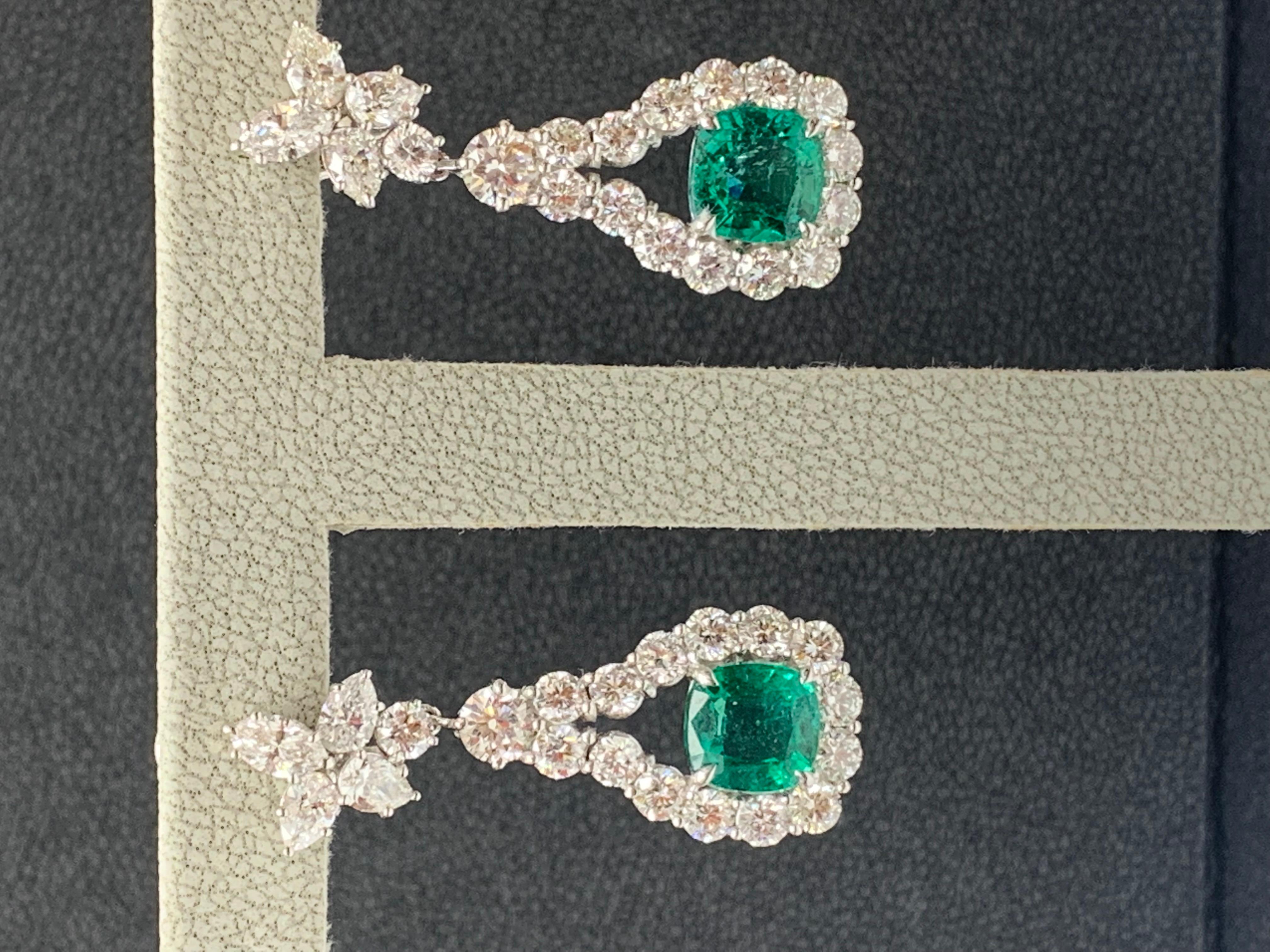 A beautiful and chic pair of drop earrings showcasing a cluster of brilliant mixed-cut diamonds, and cushion-cut emeralds set in an intricate and stylish design. 8 Mixed cut Diamonds weigh 1.62 carats in total. 2 vivid green emeralds weigh 4.62