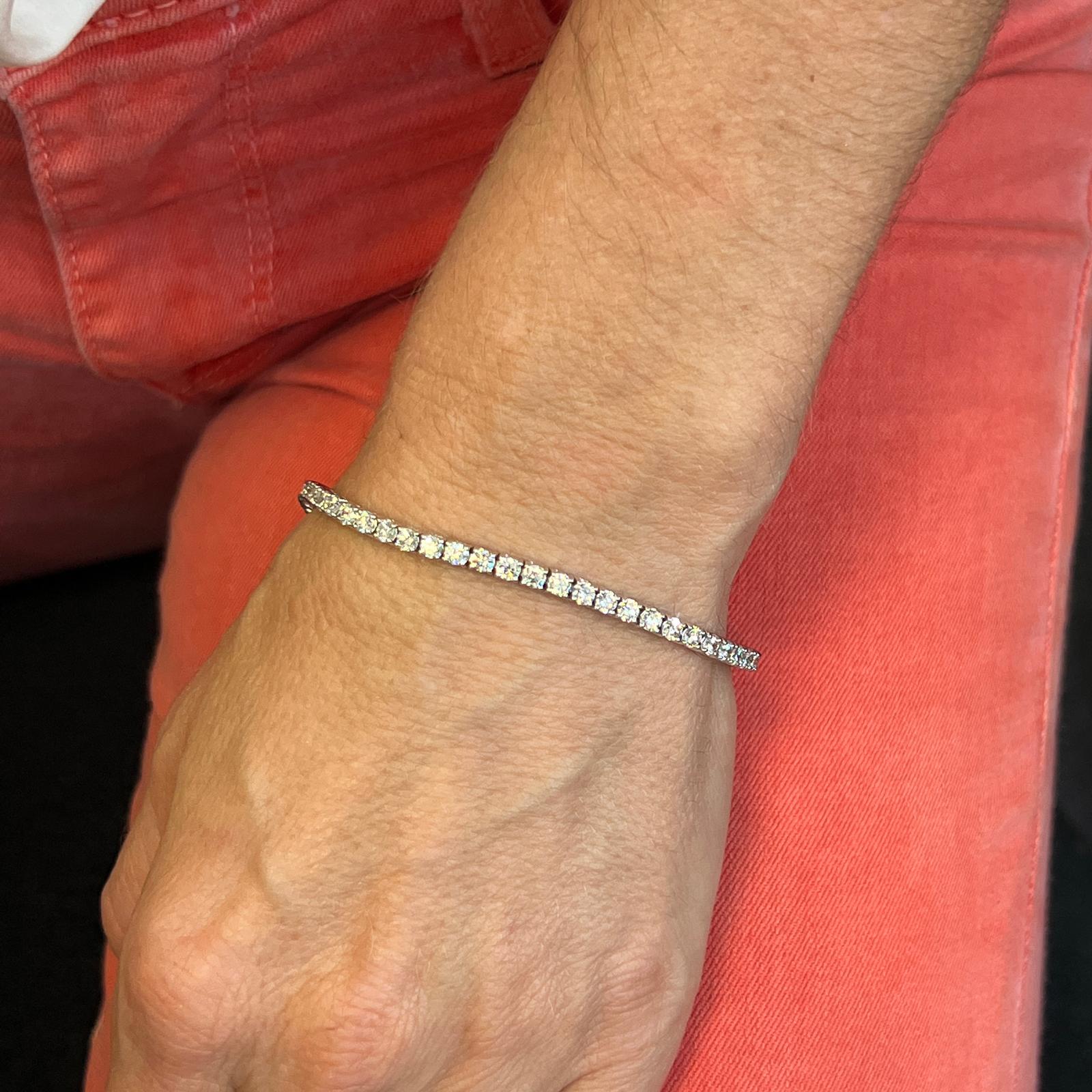 Diamond modern tennis bracelet crafted in 14 karat white gold. The bracelet features 57 round brilliant cut diamonds weighing 4.62 CTW and graded G-H color and SI1 clarity. The bracelet measures 7 inches in length and 3.1mm in width. 