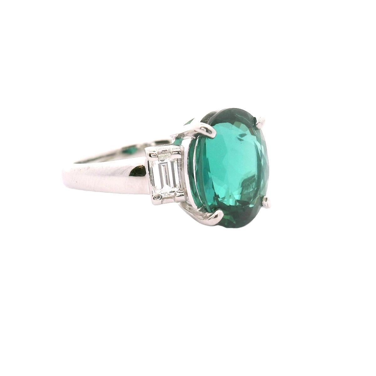 A striking 4.63 carat rare lagoon tourmaline takes center stage in this classic 3-stone ring. The tourmaline, cut in an elegant oval shape, radiates a very unique deep and vibrant green-blue color that is called “lagoon” in the trade. Flanking the