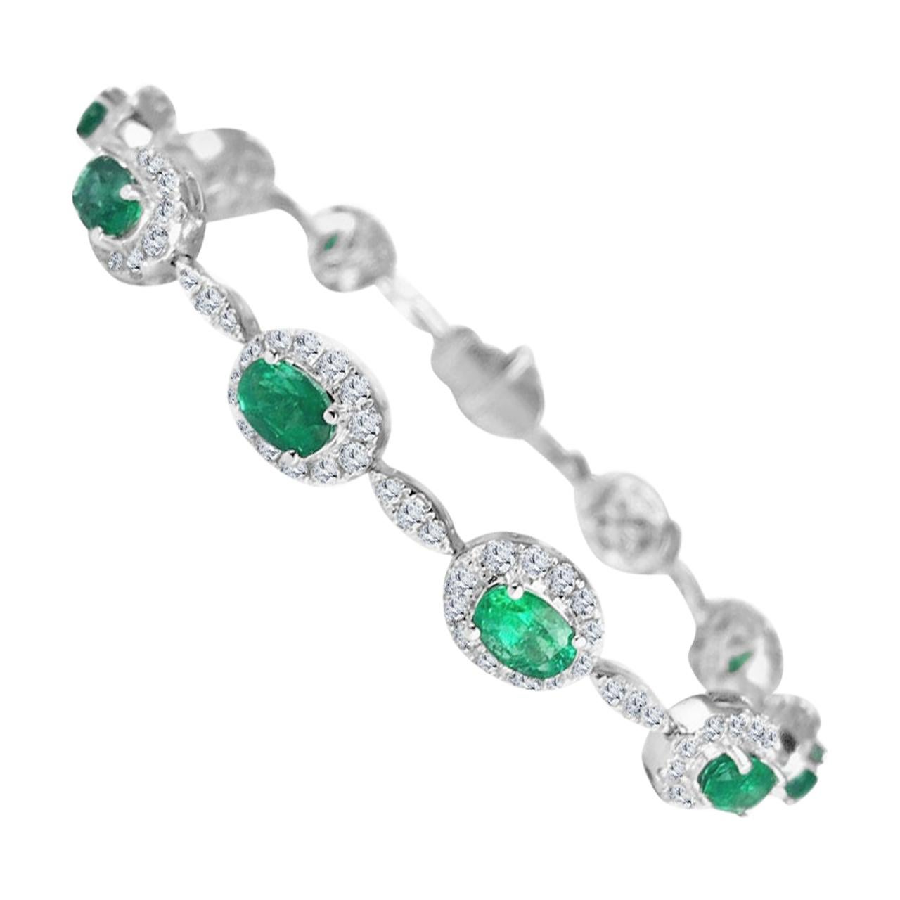 Elegantly showcasing the radiance of 11 oval-cut emeralds, each graced by a halo of round natural diamonds, this bracelet alternates these gem-encrusted links with trios of natural diamonds, artfully mimicking the allure of a singular marquise-cut