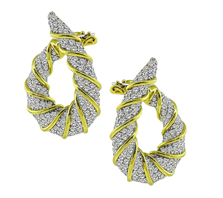 This is a stunning pair of 18k yellow and white gold earrings. The earrings feature sparkling round cut diamonds that weigh approximately 4.63ct. The color of these diamonds is G-H with VS clarity. The earrings measure 36mm by 26mm and weigh 27