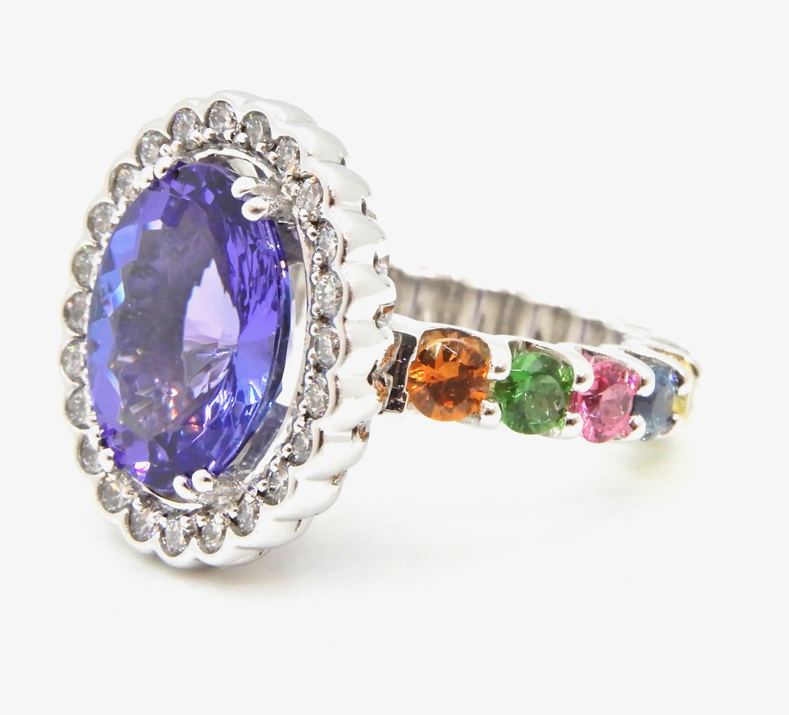 This 4.65 Carat Oval Tanzanite Diamond and Rainbow Gemstone Cocktail Ring just says FUN!

Featuring a 4.65 carat oval purplish blue tanzanite in 4 split claws, surrounded by 24 x 0.01 carat round cut brilliant G VS diamonds in scalloped edge