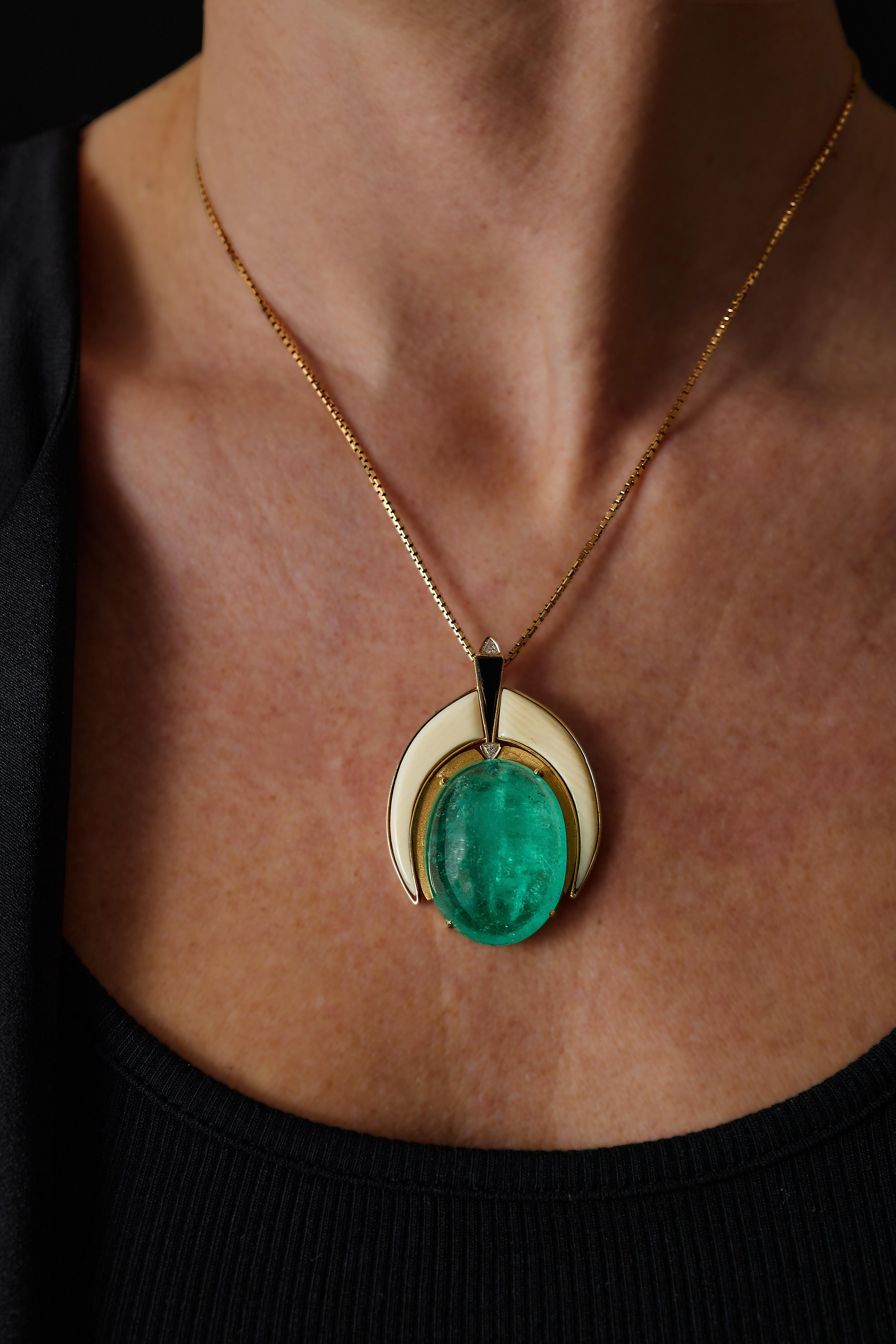 Art Deco emerald pendant, 18k gold, cabochon cut Emerald approx. 46.7 ct measures: 29.1 x 22.2 x 10.3mm, framed by two pieces of cut ivory, onyx and 2 triangle-cut diamonds. CITES permit is included.

Pendant dimensions approx. 1.97