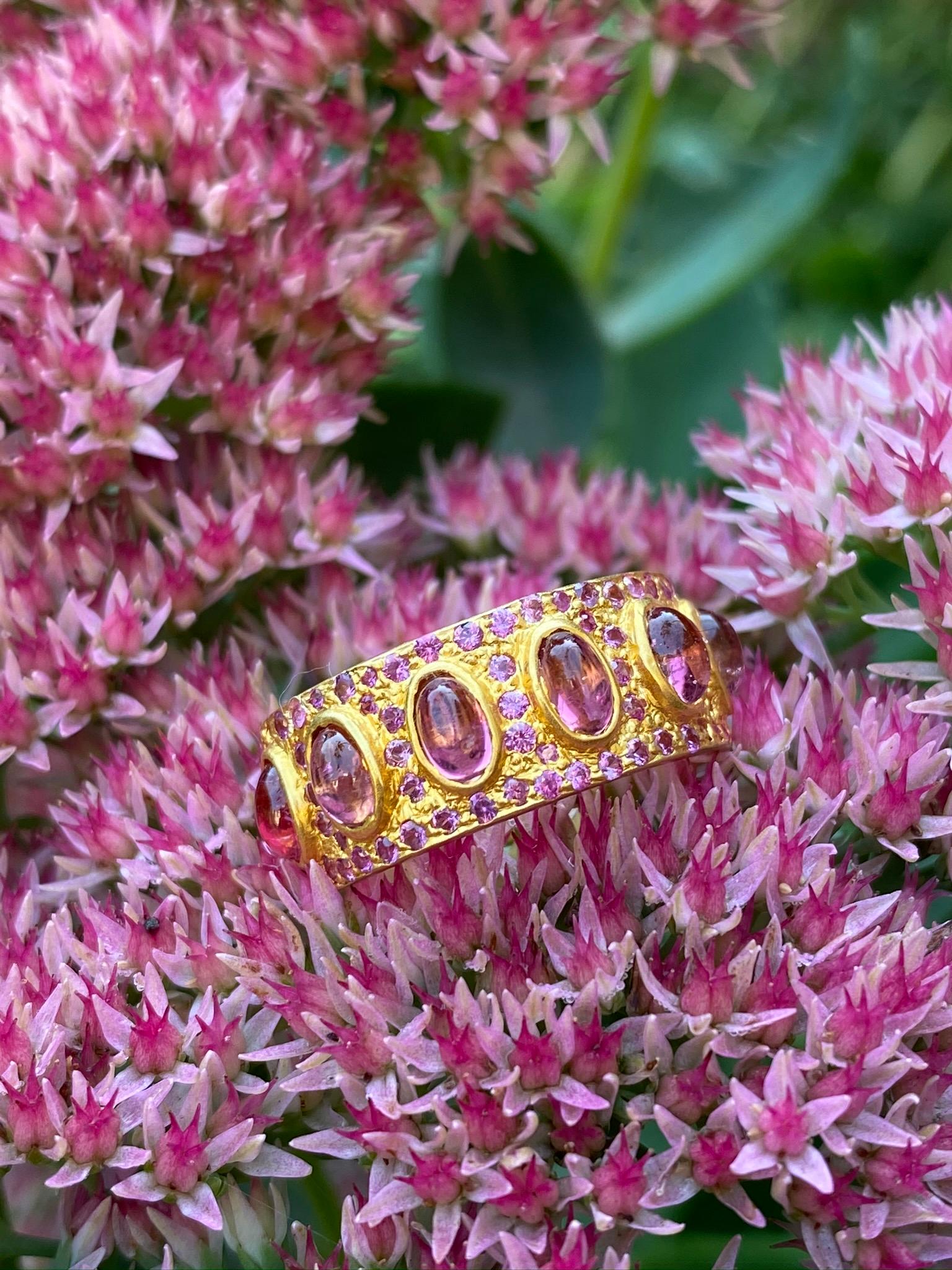Designed by award winning jewelry designer, Lauren Harper, this stunning eternity band is studded in 4.68 carats of brilliant Pink cabachon Tourmalines that are surrounded by faceted pink Tourmaline, and set in a warm tone of 18kt Gold. Comfortable