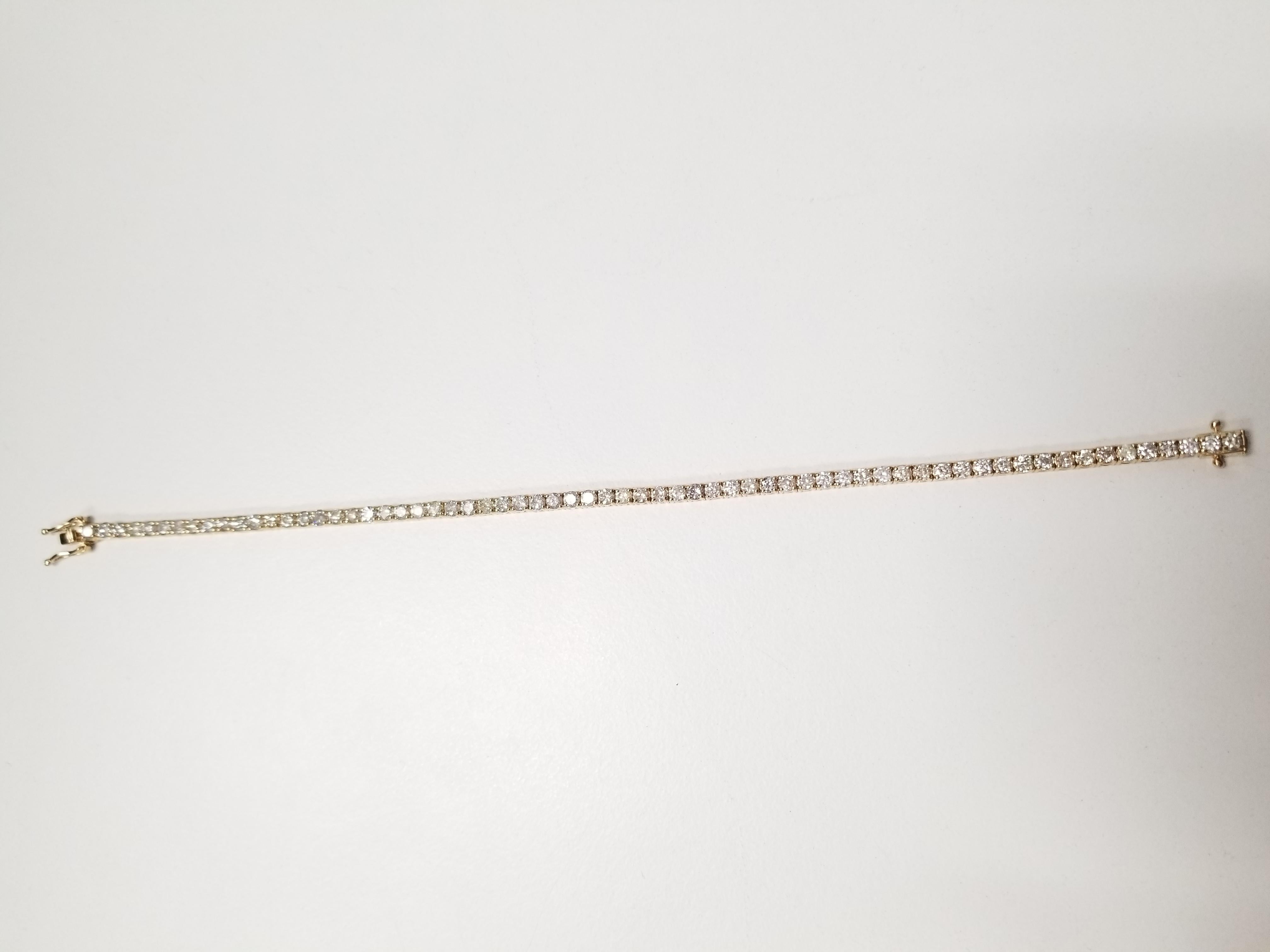 A quality tennis bracelet, containing 65 pcs of round-brilliant cut diamonds. set on 14k yellow gold. each stone is set in a classic four-prong style for maximum light brilliance. 7 inch length.