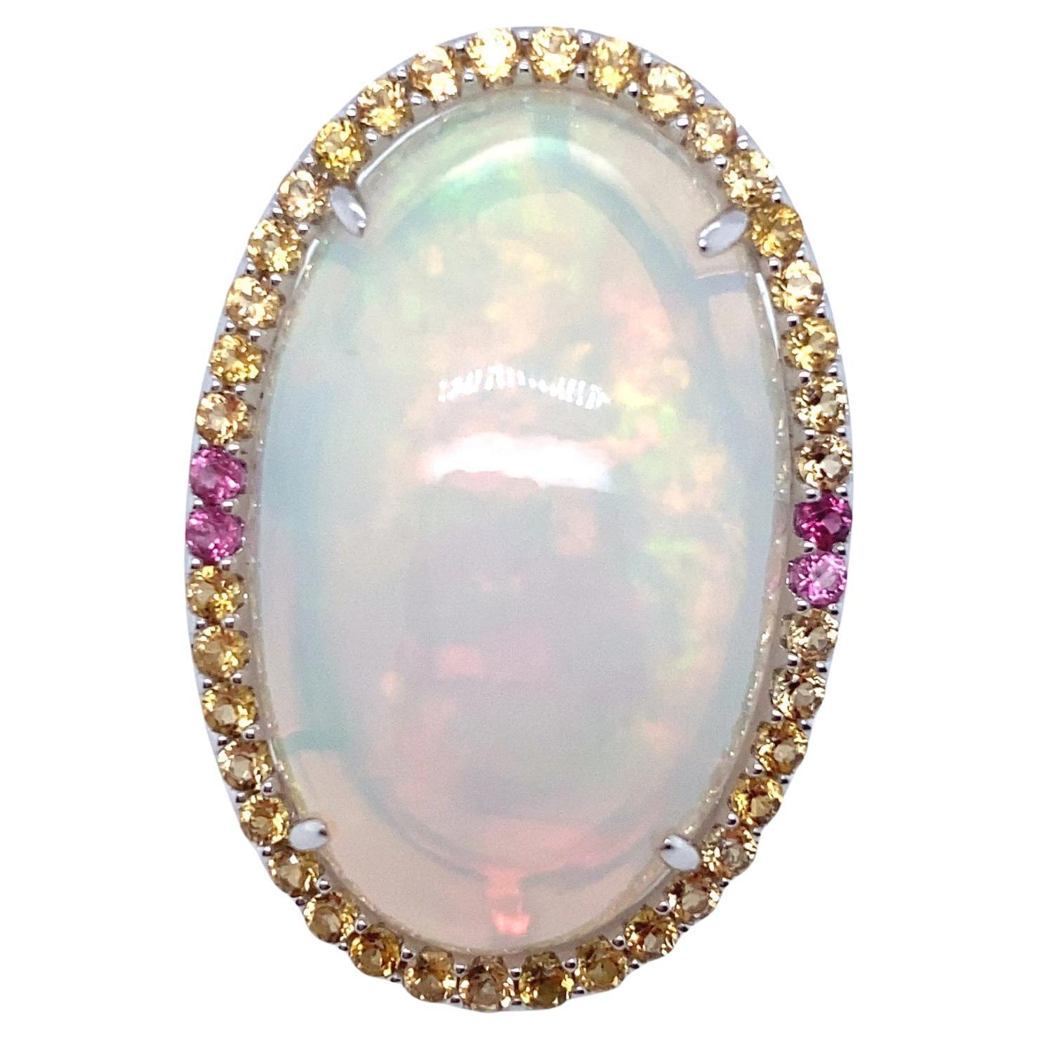 This stunning 46.86-carat oval-cut opal is gracefully surrounded by a halo of 1.46 carats of sapphires. The impressive opal is meticulously hand-cut and polished to perfection, set in luxurious 14k white gold. The ring is size 7 and can be resized