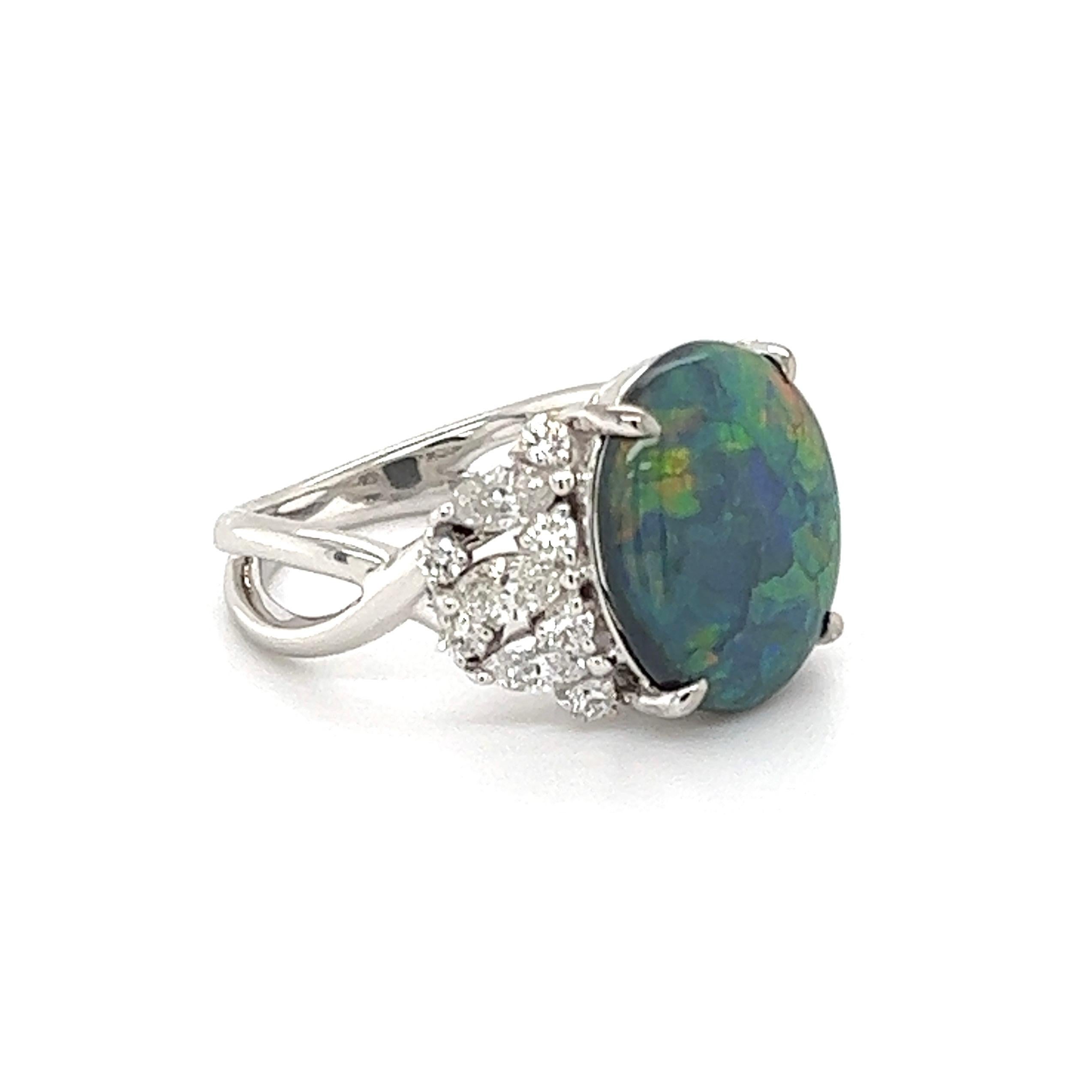 Simply Beautiful and finely detailed Cocktail Ring, center securely set with a 4.69 Carat Lightning Ridge Black Opal, weighing 4.69 Carats, either side set with Diamonds, approx. 0.94 total carat weight. Hand crafted 18K White Gold mounting. Approx.