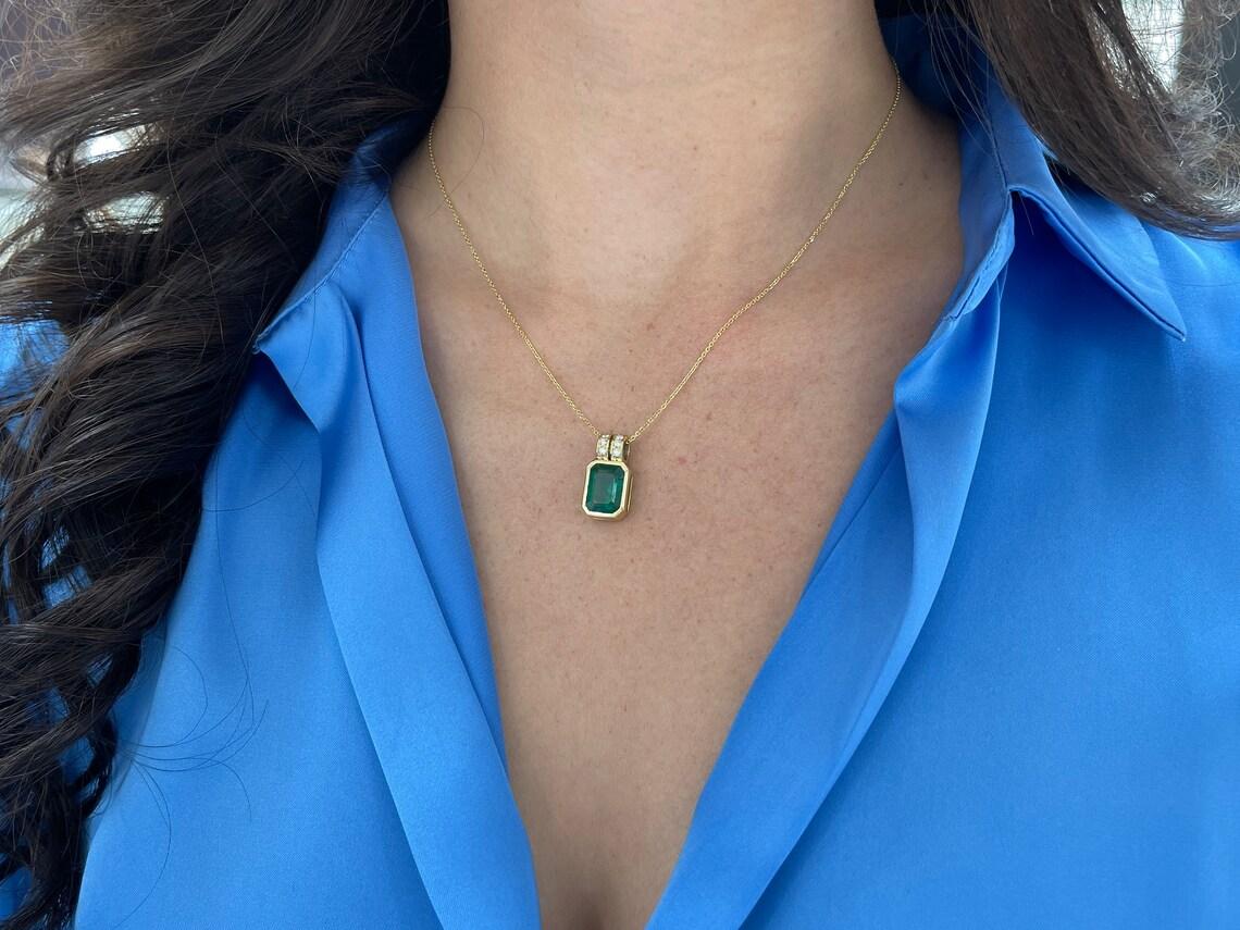Unser exquisiter Anhänger mit Smaragd- und Diamantenbesatz ist eine schillernde Verkörperung von Raffinesse und Luxus. Tauchen Sie ein in über 4,5 Karat reiner, sattgrüner Güte mit einem Edelstein im Smaragdschliff aus Sambia, der mit seiner tiefen,