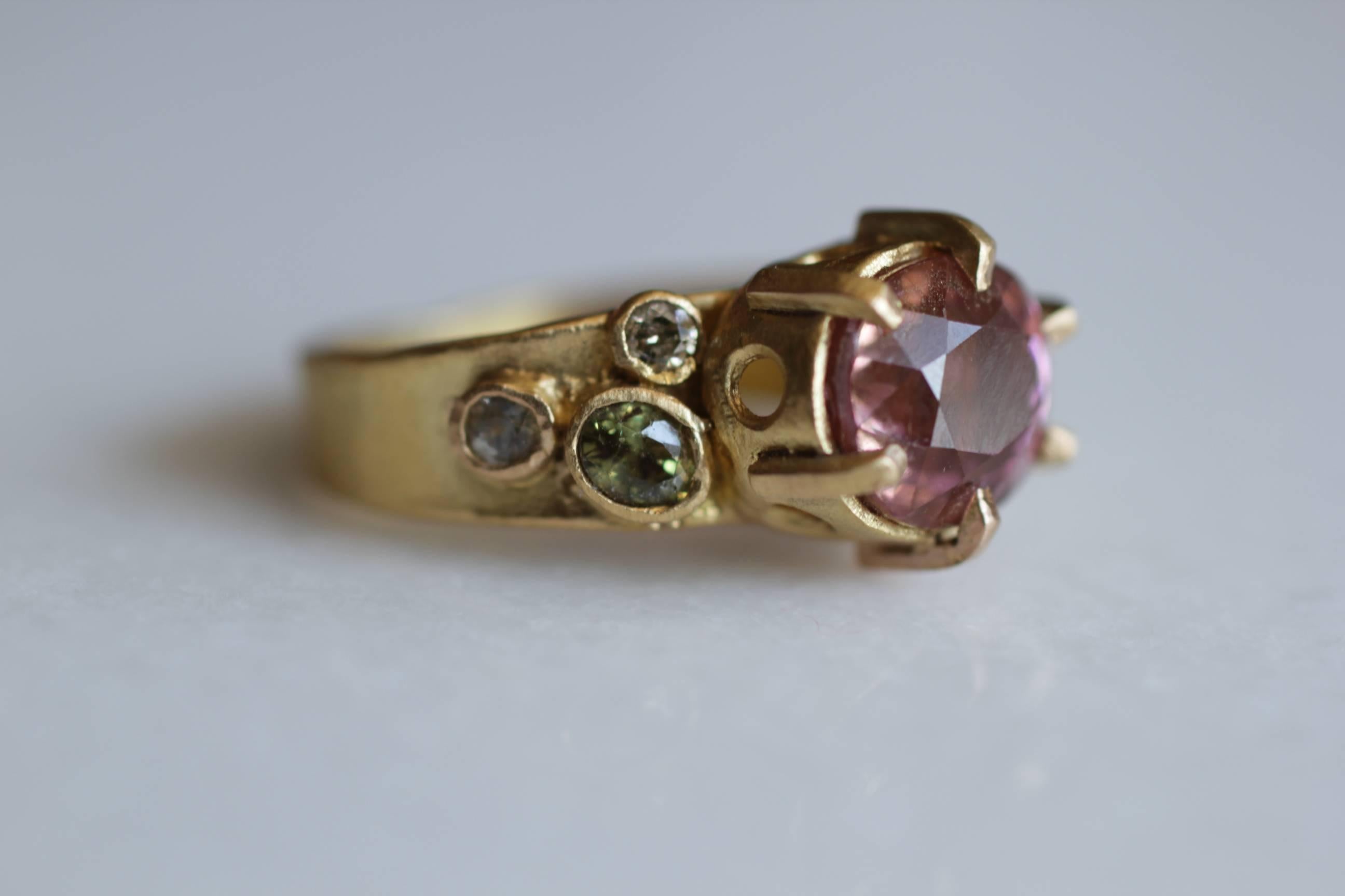 Rhododendron Ring. This one of a kind handmade 21k solid yellow gold ring features a beautiful 4.6 Ct peach tourmaline surrounded by colored stones, conjuring a vision of a flower nestled in its foliage. Can be worn alone of for a more dramatic