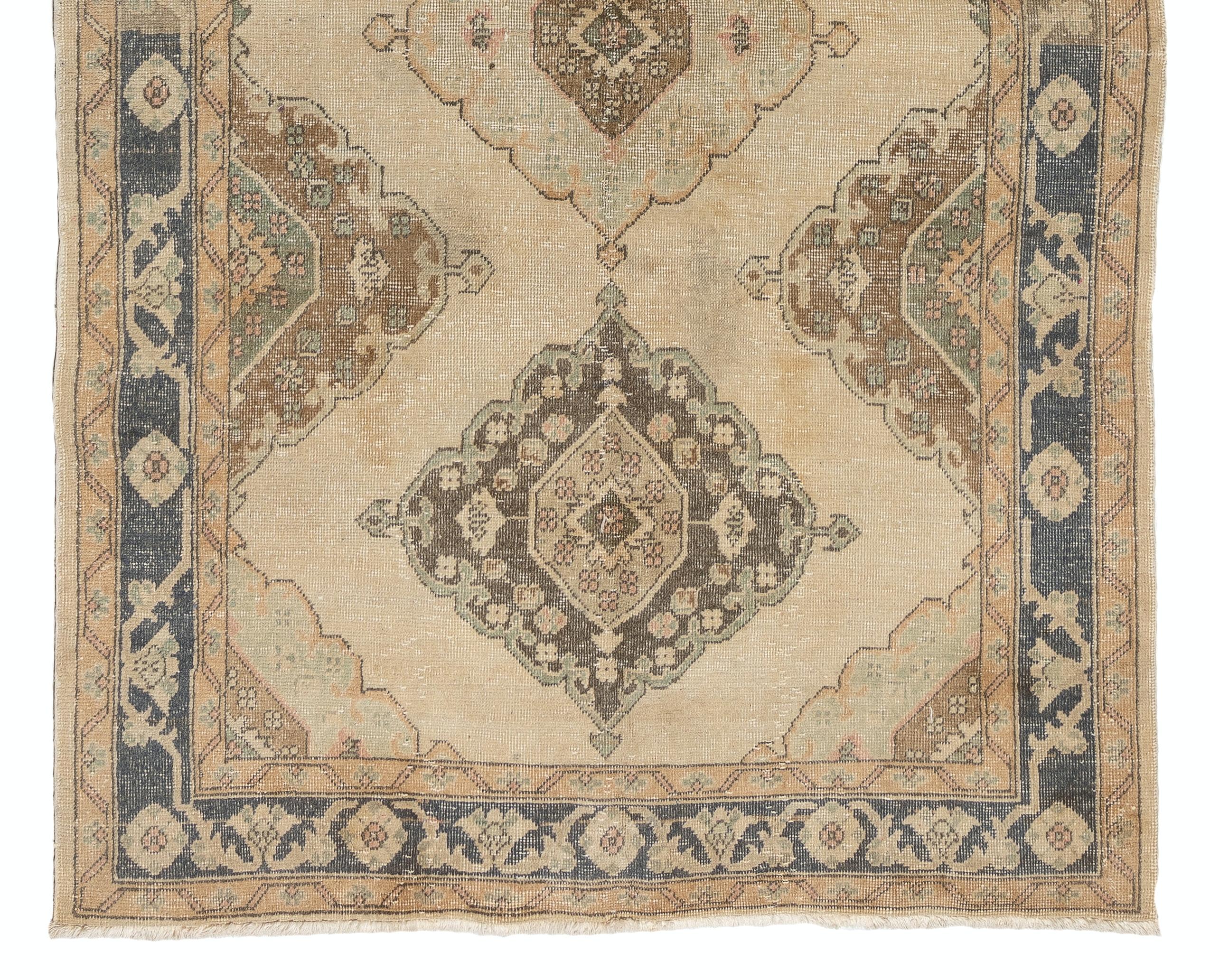 A vintage Turkish runner rug in neutral colors. It was hand-knotted in the 1960s with low wool on cotton foundation and features a multiple medallion design. It is in very good condition, professionally-washed, sturdy and suitable for areas with