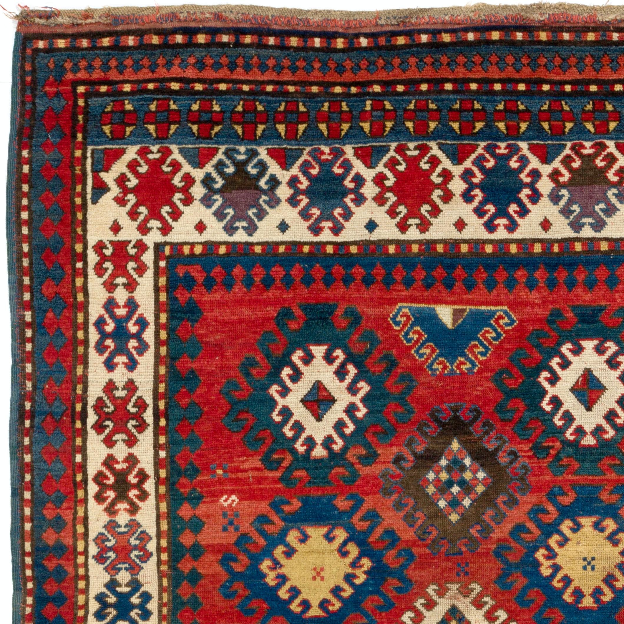 A radiant, alluring antique Caucasian Kazak rug from the 1860s in a gorgeous color palette with a bold, dynamic design. The floating multiple hooked medallions at the center, each containing wheel of life and eye motifs in glowing marine blue, deep