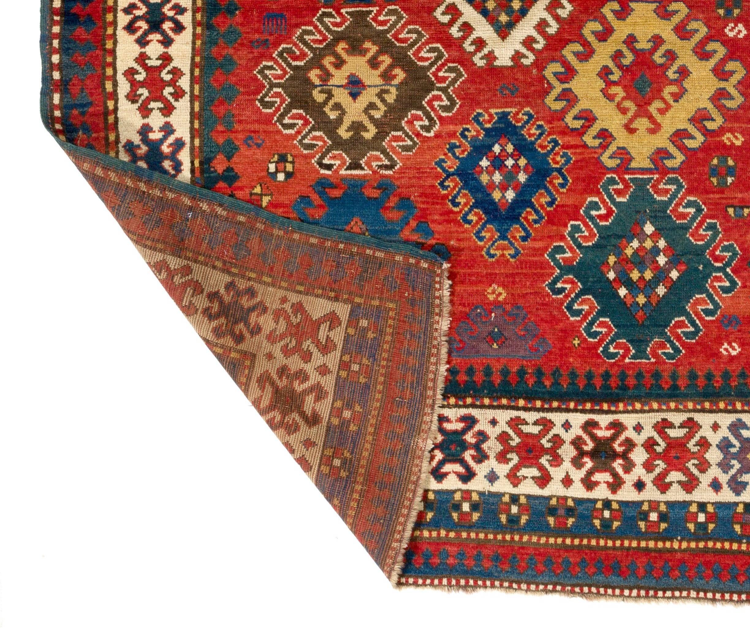 Un radieux et séduisant tapis Kazak caucasien ancien des années 1860 dans une magnifique palette de couleurs avec un design audacieux et dynamique. Les multiples médaillons crochetés flottants au centre, chacun contenant des motifs de roue de vie et