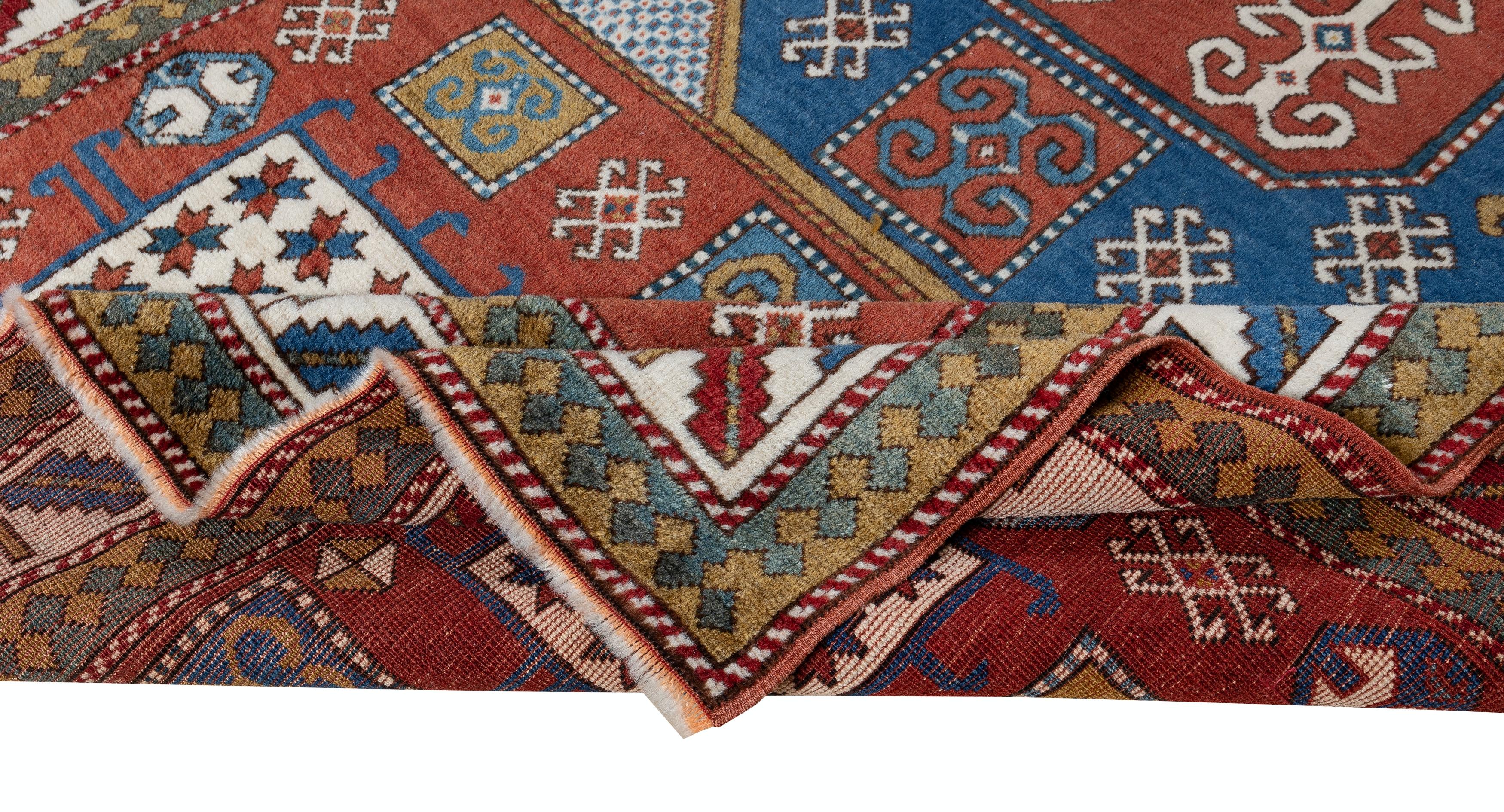 An authentic brand-new hand-knotted wool rug made in Turkey with a Caucasian Kazak design featuring bold geometric angular forms in contrasting scales, each containing a symbolic motif such as stars, ram's horns, wheels of fortune, eyes and trees of