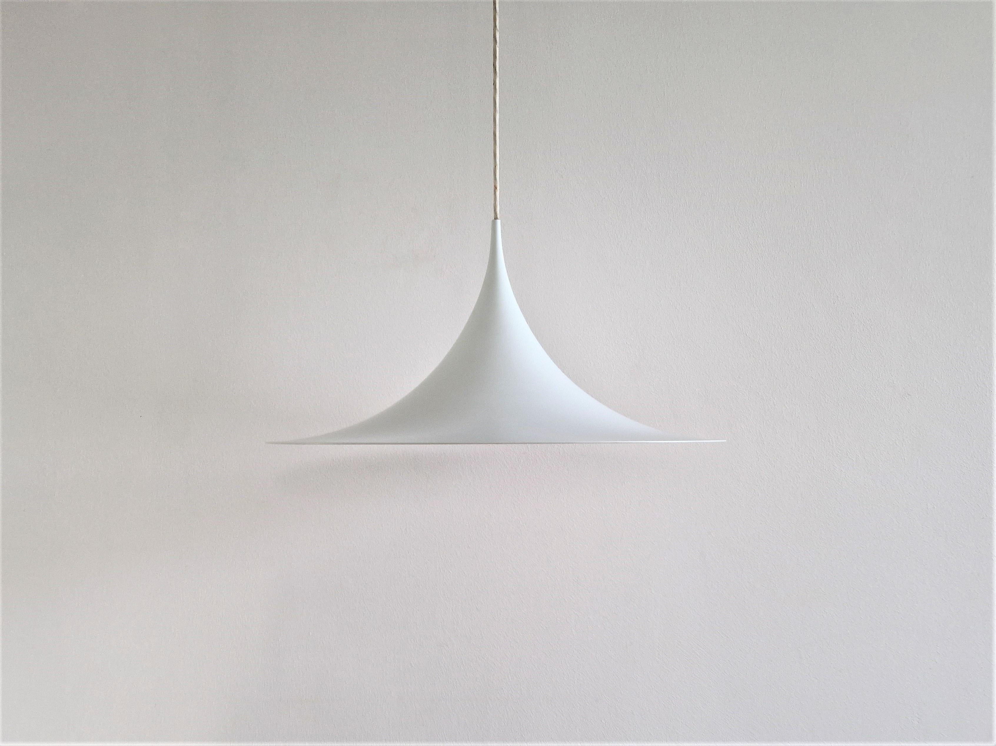 This famous model 'Semi' or 'witch hat' pendant lamp was designed by Claus Bonderup and Torsten Thorup for Fog & Mørup in 1968.  An iconic pendant that is a true example of a timeless design. This piece is in white lacquered metal with a diameter of