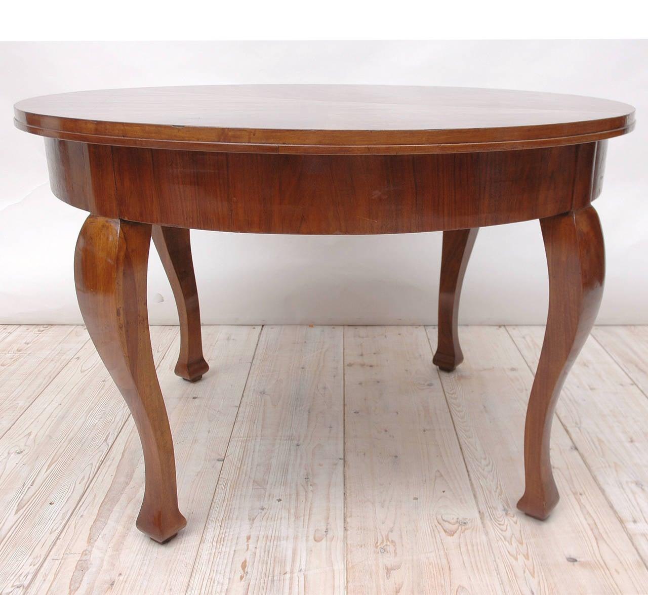 Très belle table Art Déco française en noyer avec un plateau rond en noyer figuré reposant sur des pieds cabriole stylisés. Offre un look frais et classique avec un design fin et épuré qui met l'accent sur le jeu somptueux des grains de bois