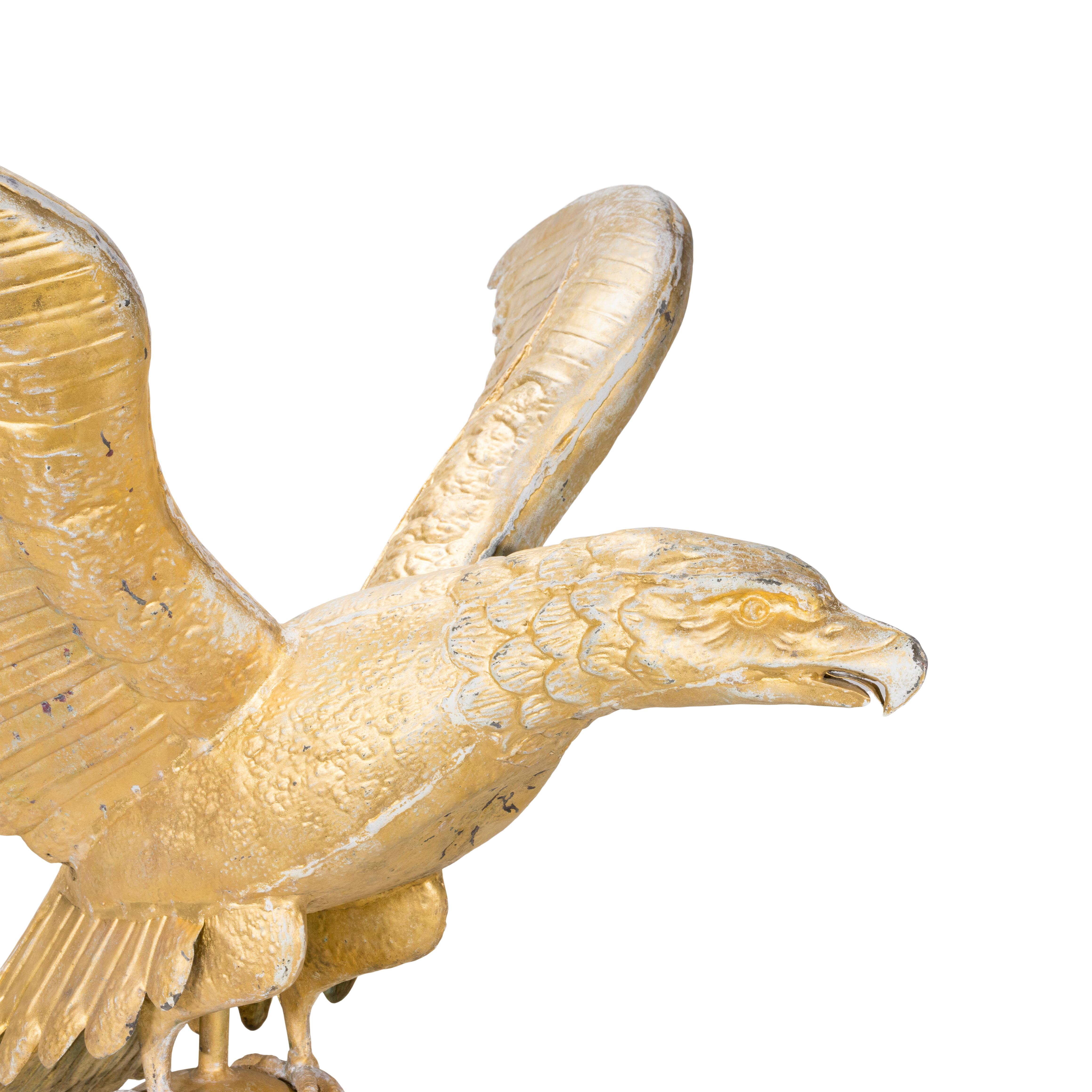 Wetterfahne in Form eines kupfernen Adlers. Sehr große, hohle Adlerform mit ausgebreiteten Flügeln und offenem Schnabel, die auf einer Kugel über einem Directional-Pfeil ruht. Drehbarer späterer Eisenfuß. Geringe Oberflächenabnutzung und
