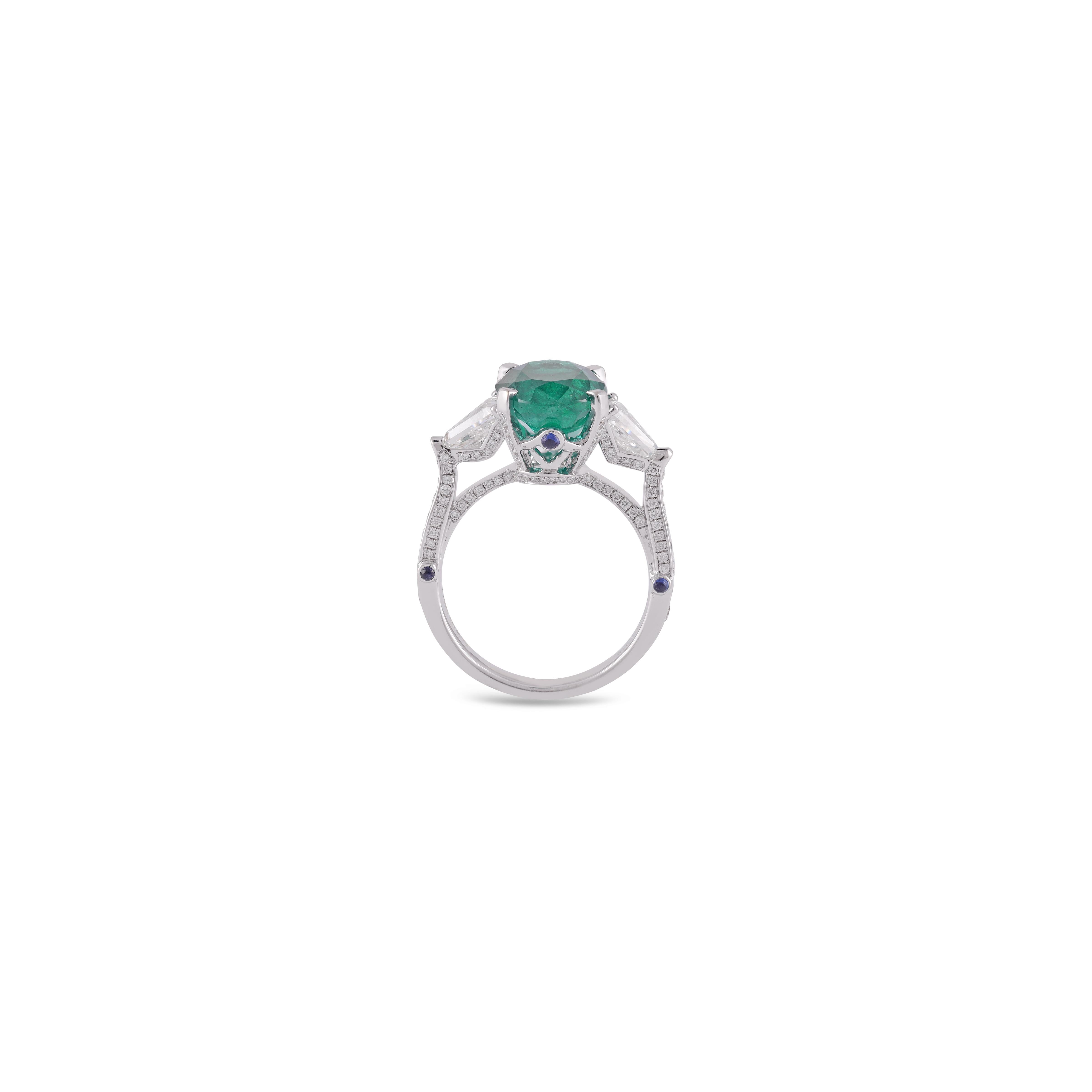 This is an elegant emerald & diamond Crown ring studded in 18k white gold with 1 piece of Oval Cut  shaped Zambian emerald weight 4.70 carat which is surrounded by 20 pieces of round shaped diamonds weight 1.49 carat & 6 piece Sapphire 0.14 carat