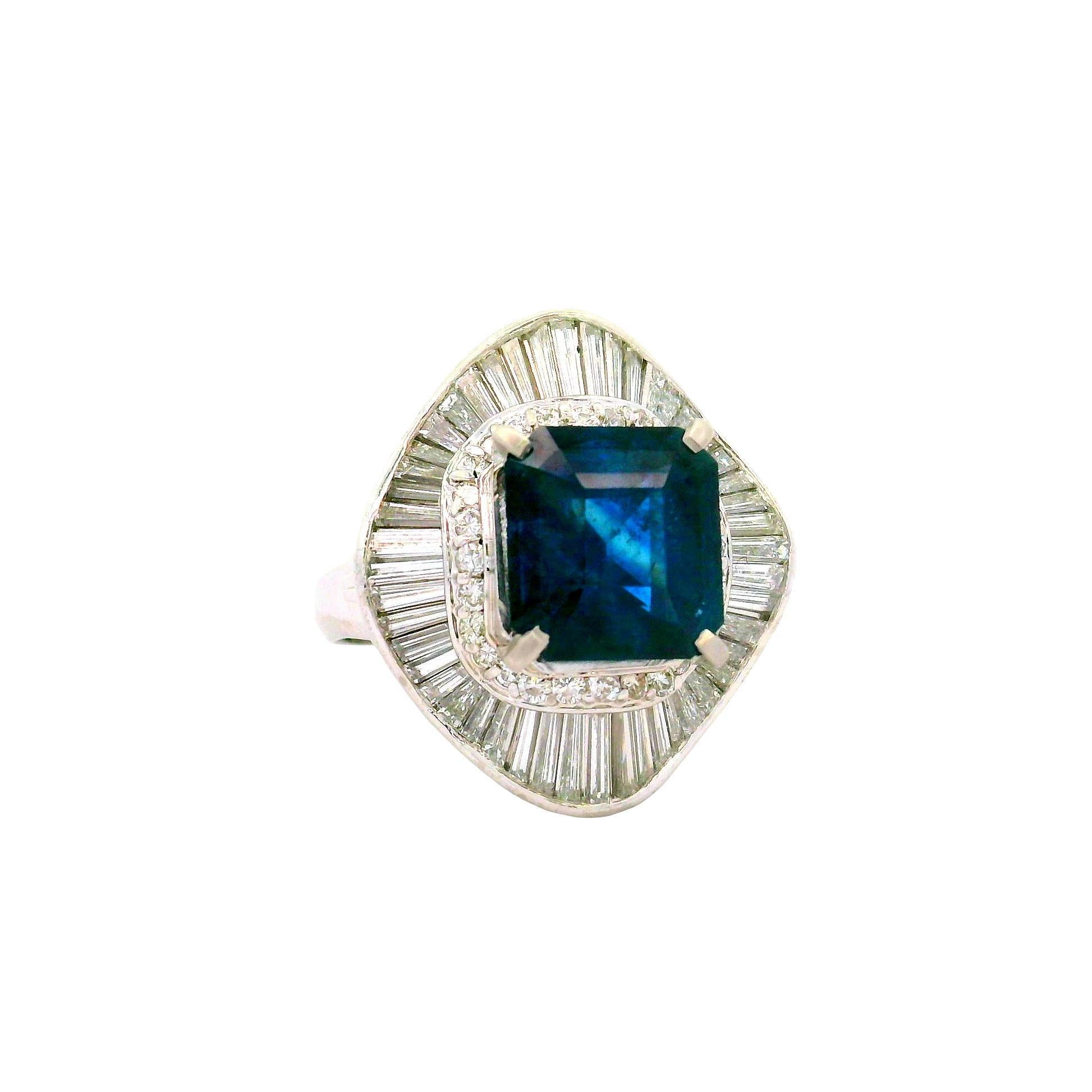 An exquisite emerald-cut blue sapphire, weighing 4.71 carats, is the focal point of this contemporary ring. The sapphire's deep blue hue captivates the eye. Surrounding the sapphire are mixed-cut white diamonds, totaling 2.05 carats, enhancing the