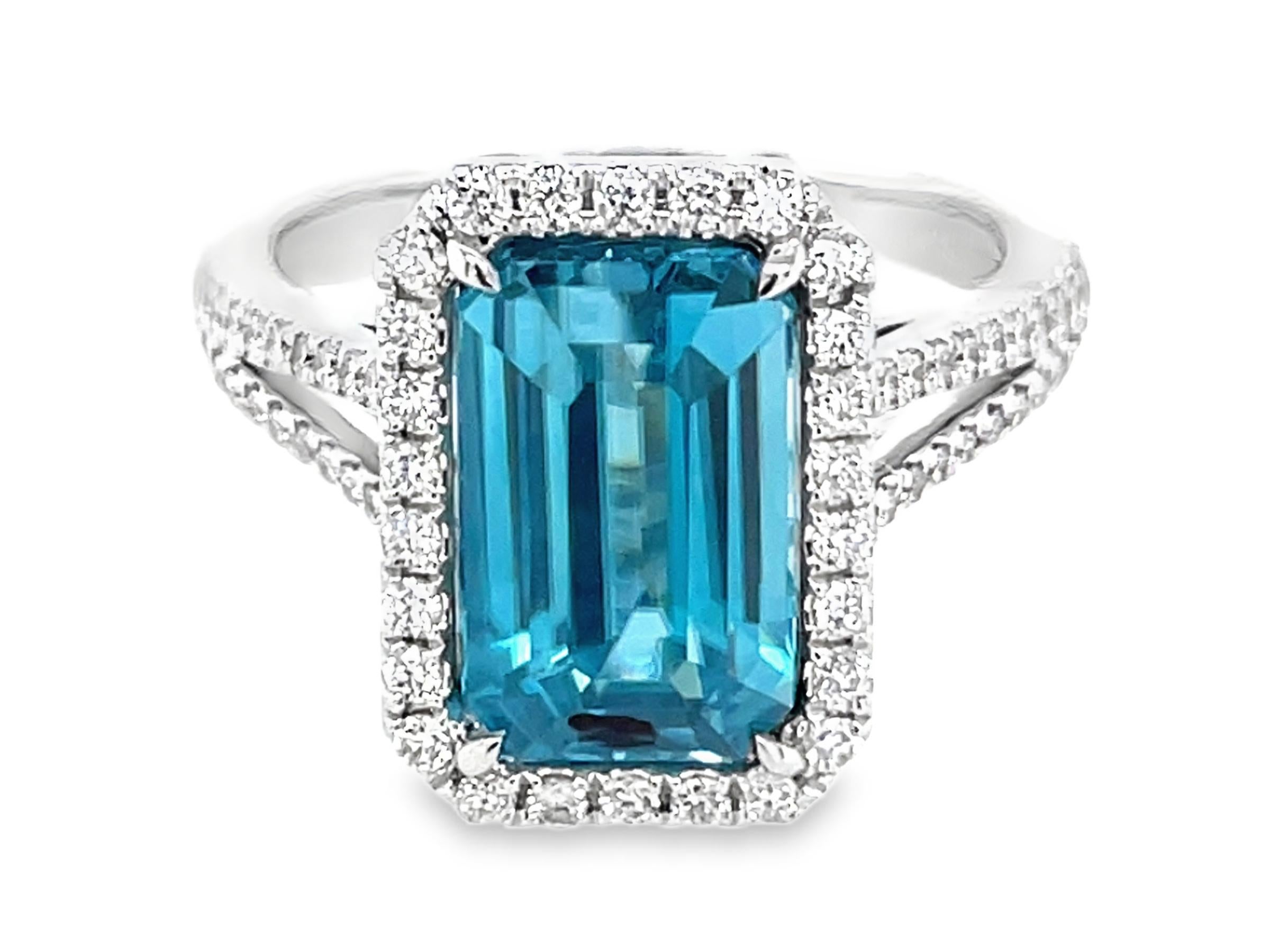 Questo bellissimo anello da cocktail presenta uno splendido zircone blu taglio smeraldo da 4,72 carati con un'aureola di diamanti, che poggia su un gambo diviso in due parti. Questo anello è incastonato in oro bianco 18 carati.

Peso totale dei
