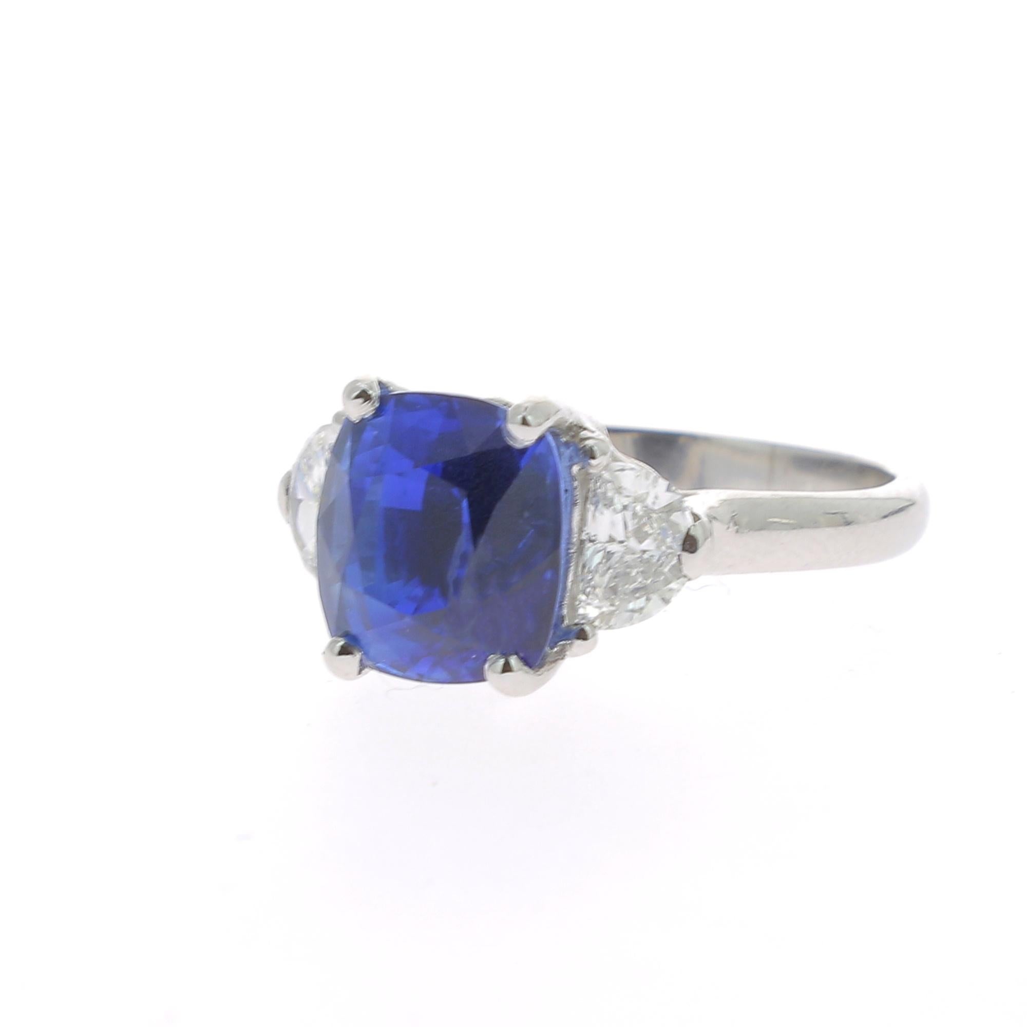 A Large and an amazing Cushion Blue Sapphire Ring flanked on each side by a single Half Moon Diamond.
The total weight of the Sapphire is 4.73 Carats, the gemstone is certified as a Blue Sapphire. 
The Half Moon Diamond weight is 0.63 Carats ( 2