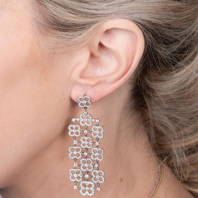 These beautiful chandelier earrings feature 4.73 carat total weight in natural round brilliant cut diamonds in seven clover shaped rows and are set in 18 karat white gold. Friction back and post. These will be your go to earring to dress up!