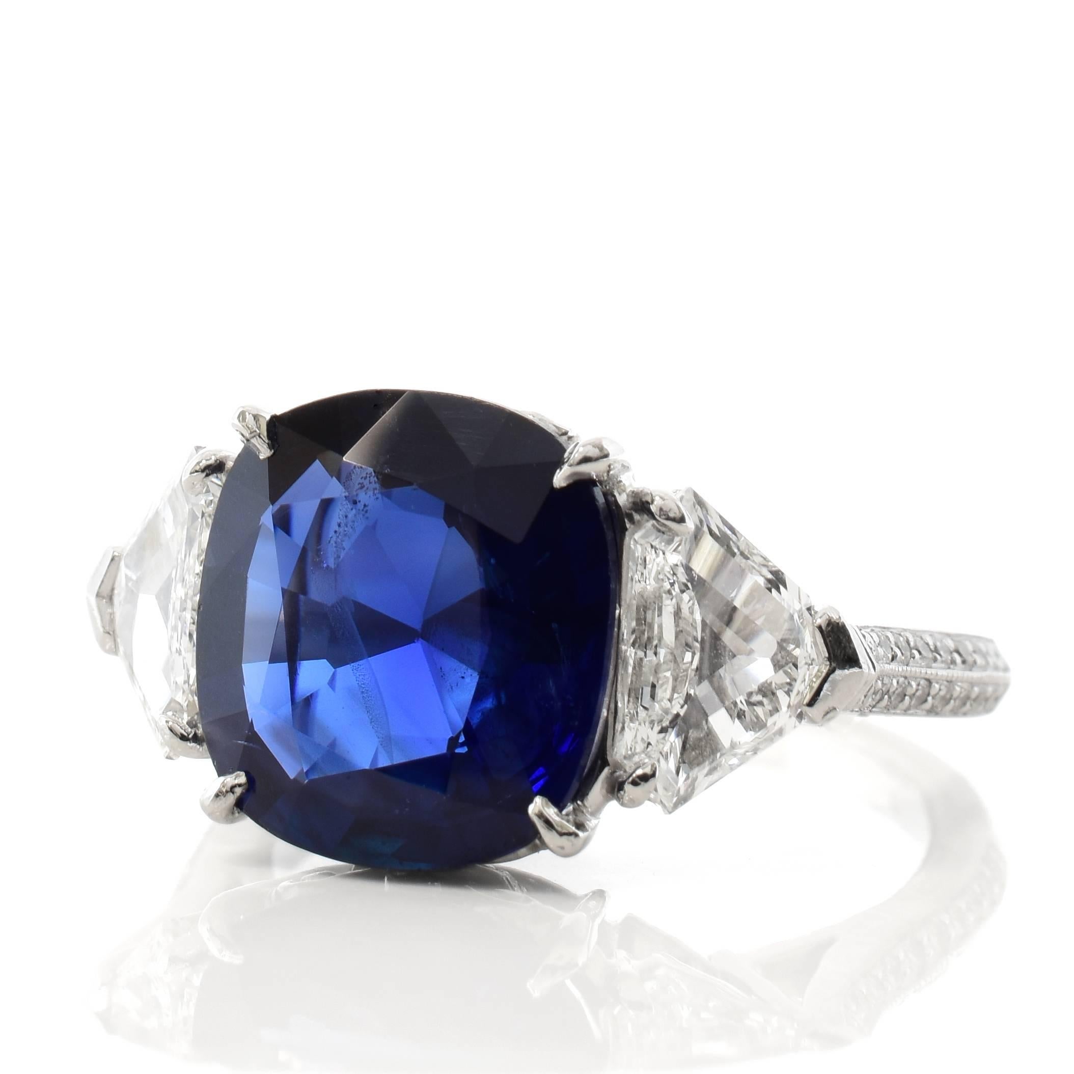 A platinum ring featuring a 4.74 carat Burma no heat sapphire center stone. The stone is certified by AGL Laboratories and GemResearch Swisslab and the original certificates are included. 

The sapphire is accented by two shield step cut diamonds