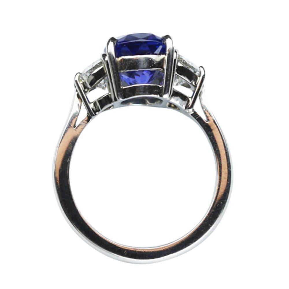 Elegant & finely detailed Solitaire Engagement Ring, center set with a securely nestled 4.74 Carat oval Vivid Blue Tanzanite, clarity: internally flawless (IF); dimensions: 12.1mm x 8.1mm, either side set with Brilliant full cut Diamonds, weighing