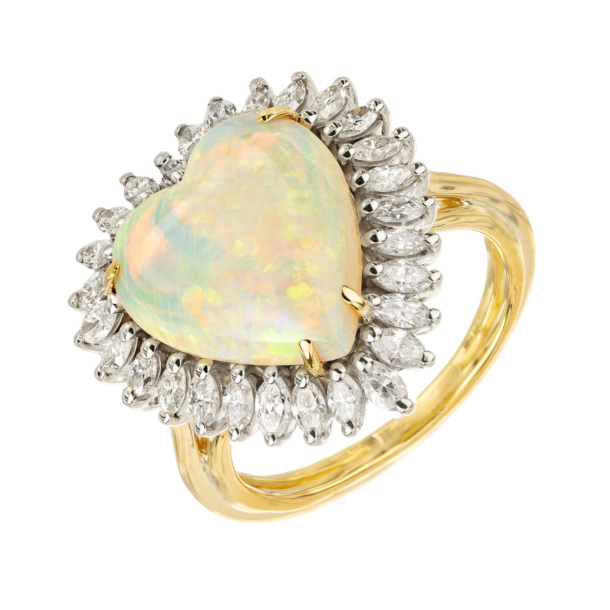 Crafted to perfection, this 4.75ct heart shaped Opal and Diamond halo gold cocktail ring is a masterpiece of elegance and sophistication. The Opal is mounted in 14k white gold with a 14k yellow gold shank. The heart-shaped opal emanates a