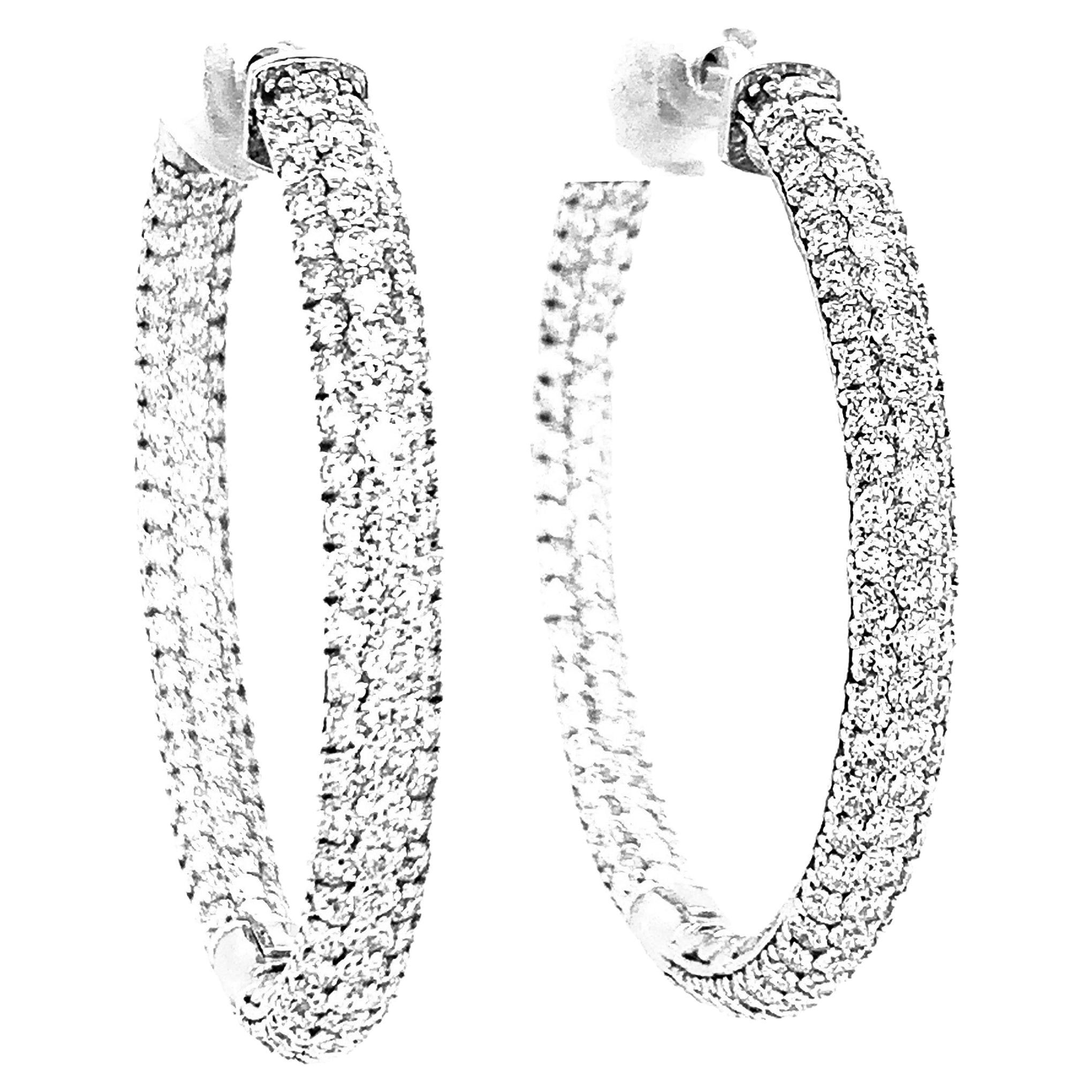 These stunning 18k white gold and diamond pave hoop earrings are set with 4.75 carats total of brilliant white diamonds for a look that will make you feel red carpet ready! Multiple rows of diamonds have been hand-set on the front and inside of