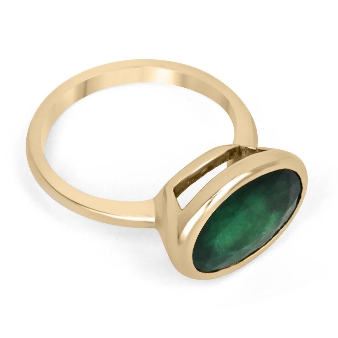 Displayed is a dark forest green emerald, solitaire, oval cut bezel ring in 14K yellow gold. This gorgeous solitaire ring carries a full 4.75-carat emerald in a sleek bezel setting. The emerald has good clarity and luster. This emerald has a great