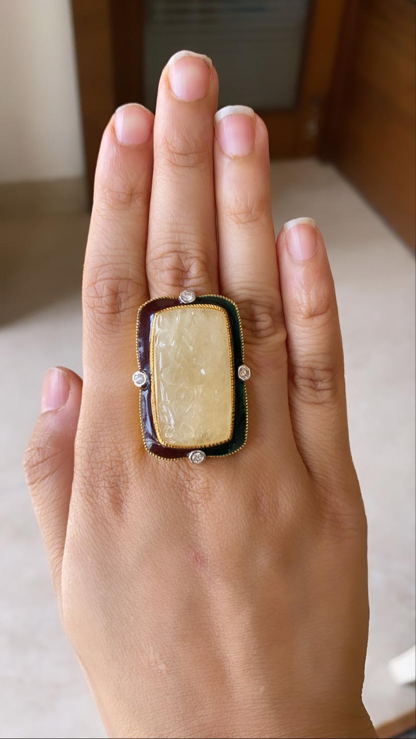 A cocktail ring set in 18k yellow gold with yellow sapphire, diamond and enamel. The natural yellow sapphire carving weight is 47.80 carats and originates from Burma ,diamond weight is .30 carats. The net gold weight is 14.701 grams and ring