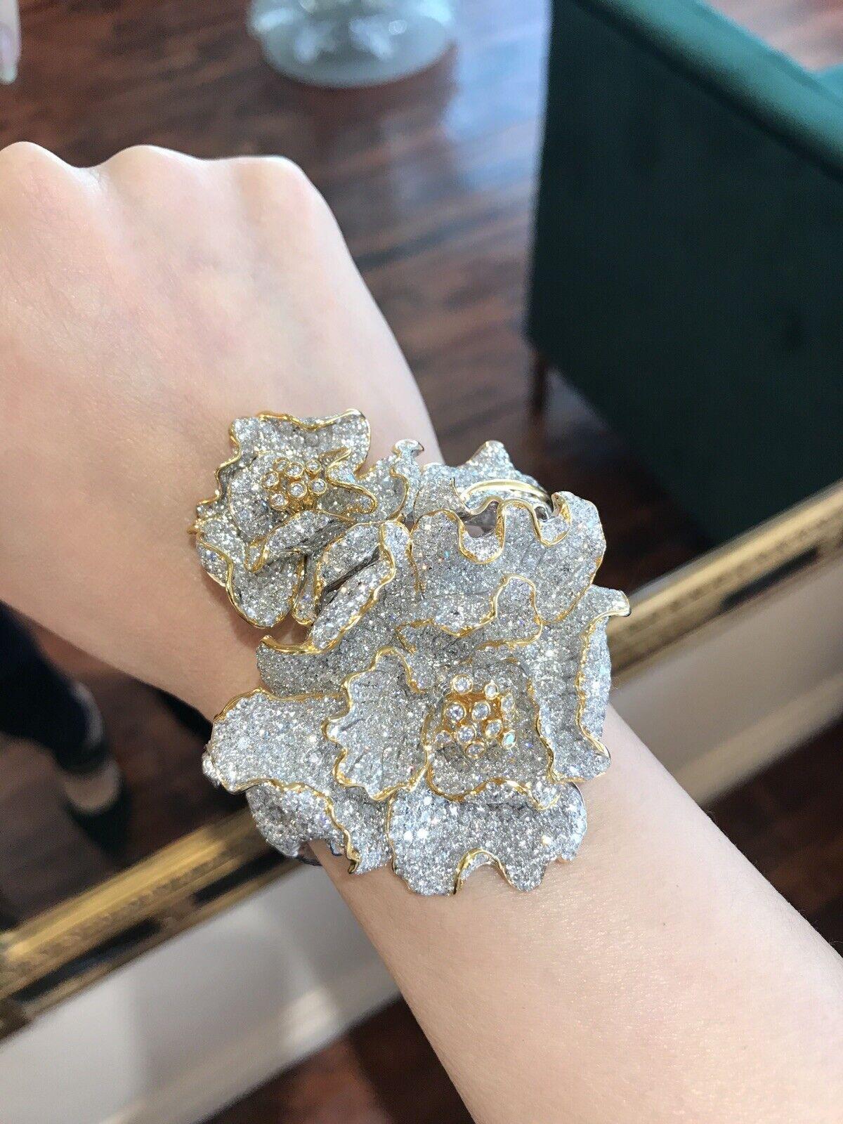 Large 47.80 carats Diamond Flower Bangle Bracelet in 18k White and Yellow Gold

Features
2 Flowers beautifully detailed with overlapping petals and leaf with Articulated center pistils in the center of each flower
Top of Bracelet is completely