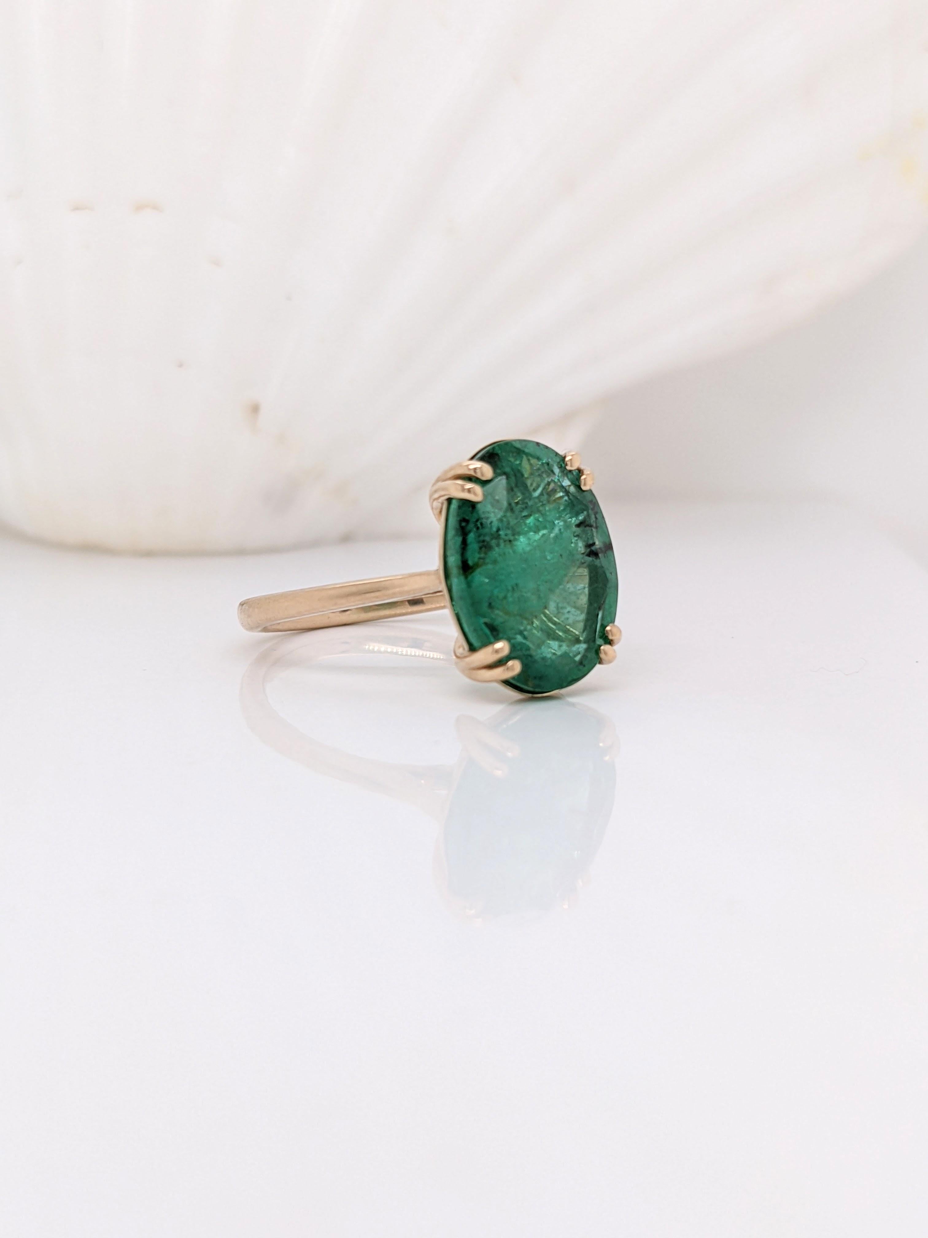 This large oval cut Zambian emerald draws you into to the depths of its intricate inclusions. A clean and minimalist setting in solid 14k yellow gold with a double prong setting and slightly tapered shank. A minimalist ring design perfect for an