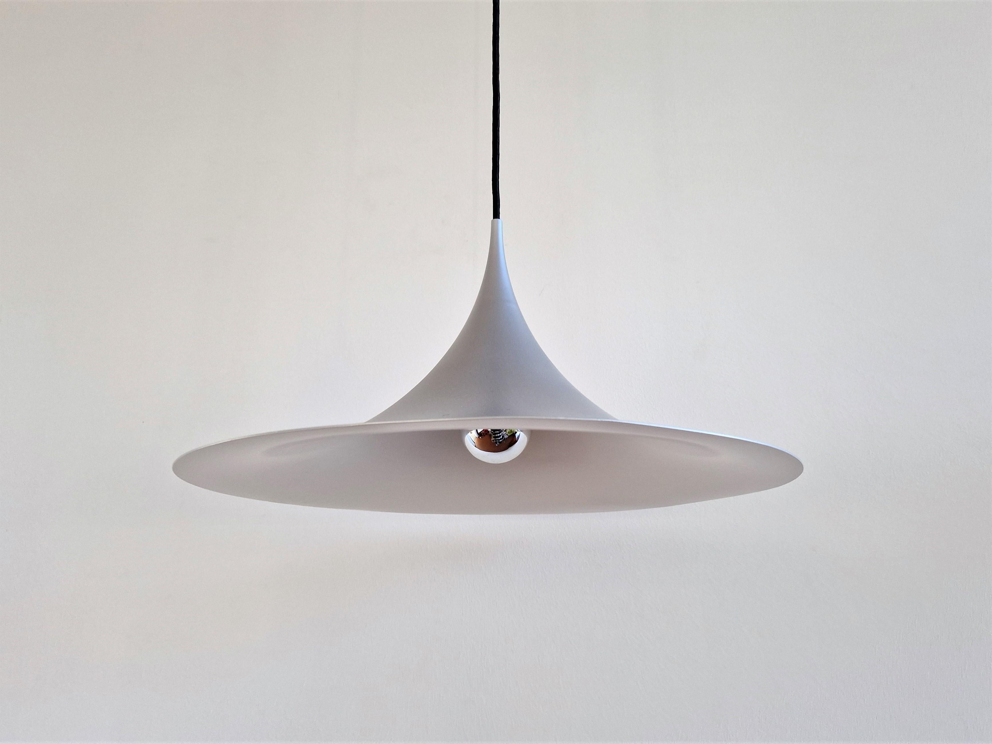 This famous model 'Semi' or 'witch hat' pendant lamp was designed by Claus Bonderup and Torsten Thorup for Fog & Mørup in 1968. An iconic pendant that is a true example of a timeless design. This piece has a diameter of 47 cm and is recently