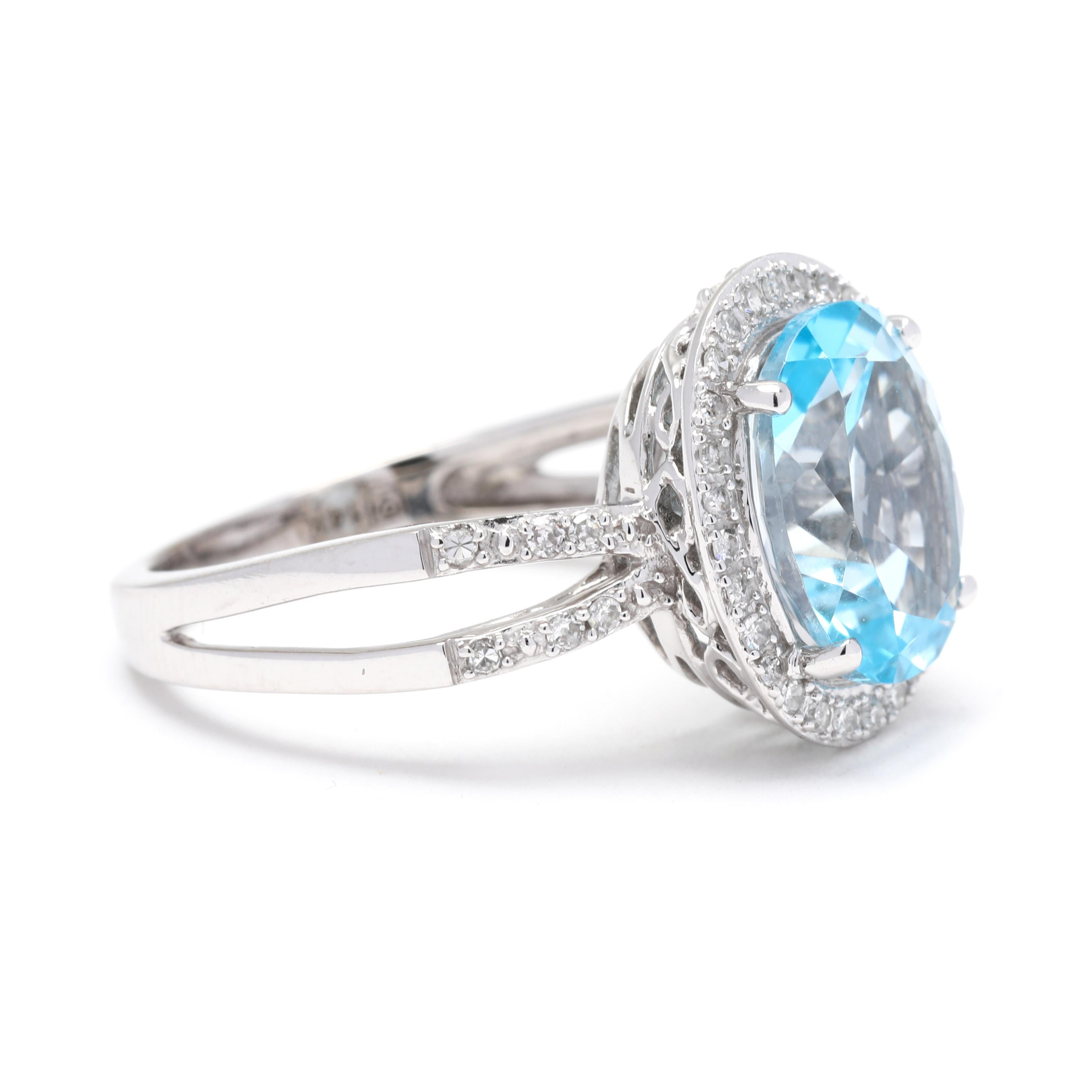 This beautiful ring showcases a 4.7 carat blue topaz gemstone surrounded by a halo of sparkling diamonds. The split shank design adds a modern twist to this classic piece. The ring is made of 14k white gold, giving it a timeless and luxurious look.