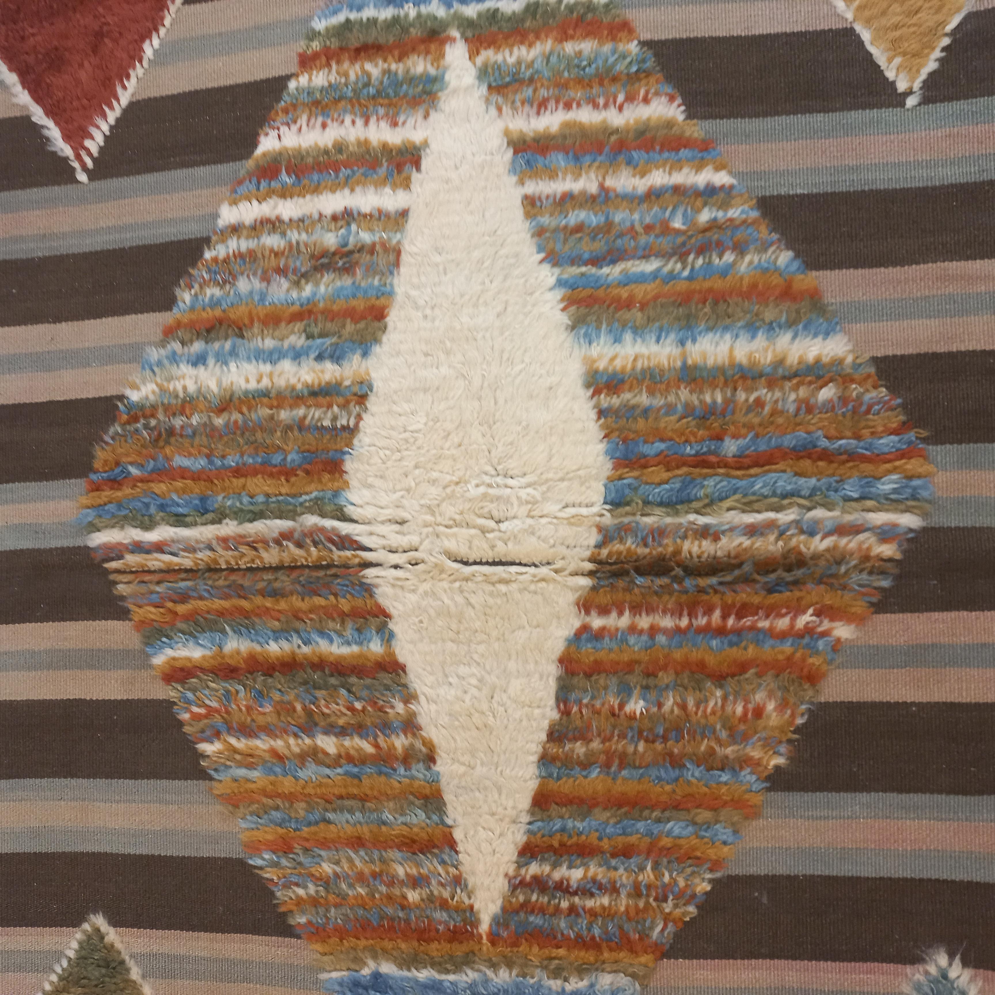 Una alfombra contemporánea anudada a mano TULU (palabra turca que significa suave, acogedora y de pelo alto) hecha de fina lana de cordero hilada y teñida a mano. 
Está en parte anudado a mano (con pelo) y en parte tejido plano (sin pelo) como se