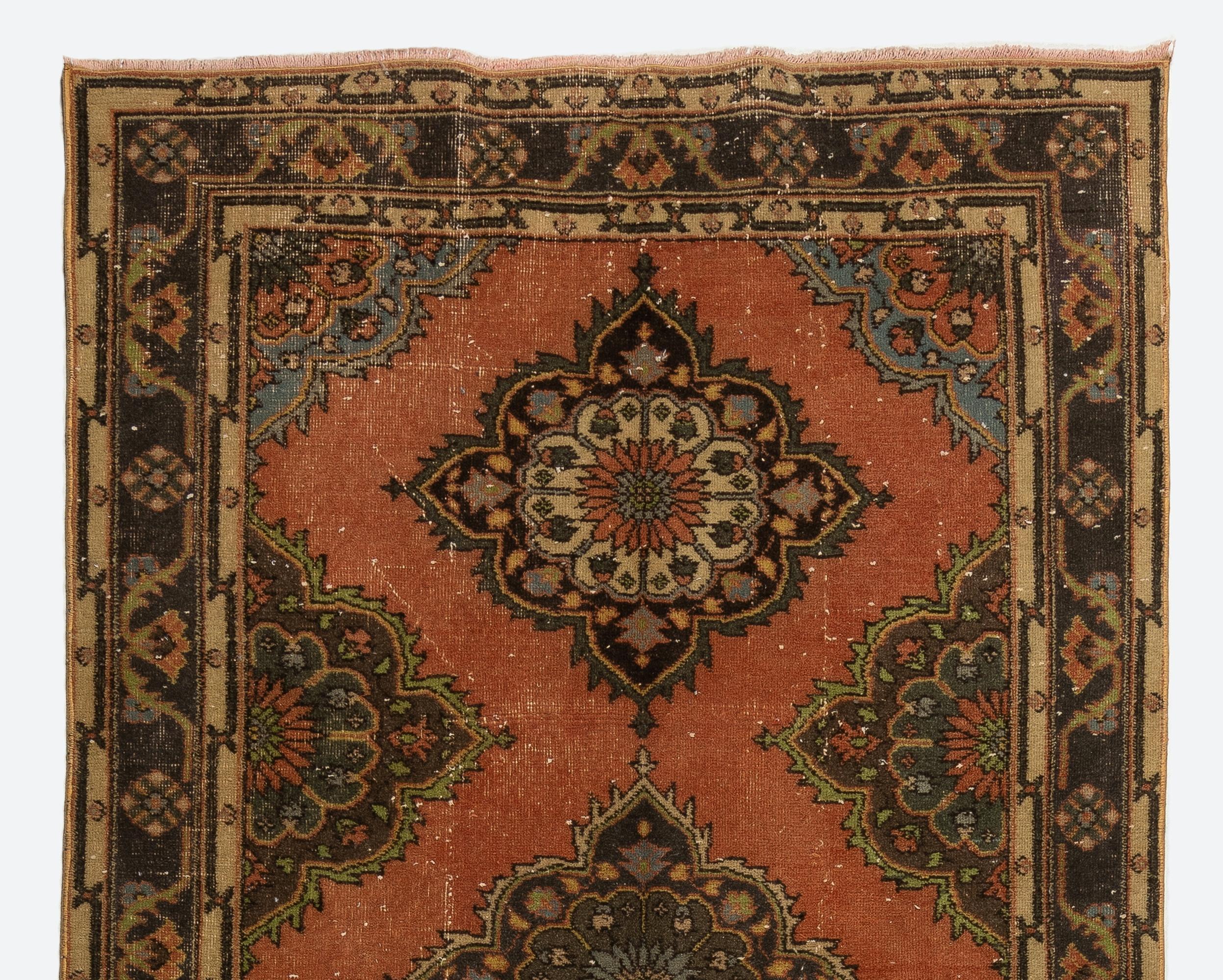 A Turkish runner rug in red, brown and beige. It was hand-knotted in the 1960s with low wool on cotton foundation and features a multiple medallion design. It is in very good condition, professionally-washed, sturdy and suitable for areas with high