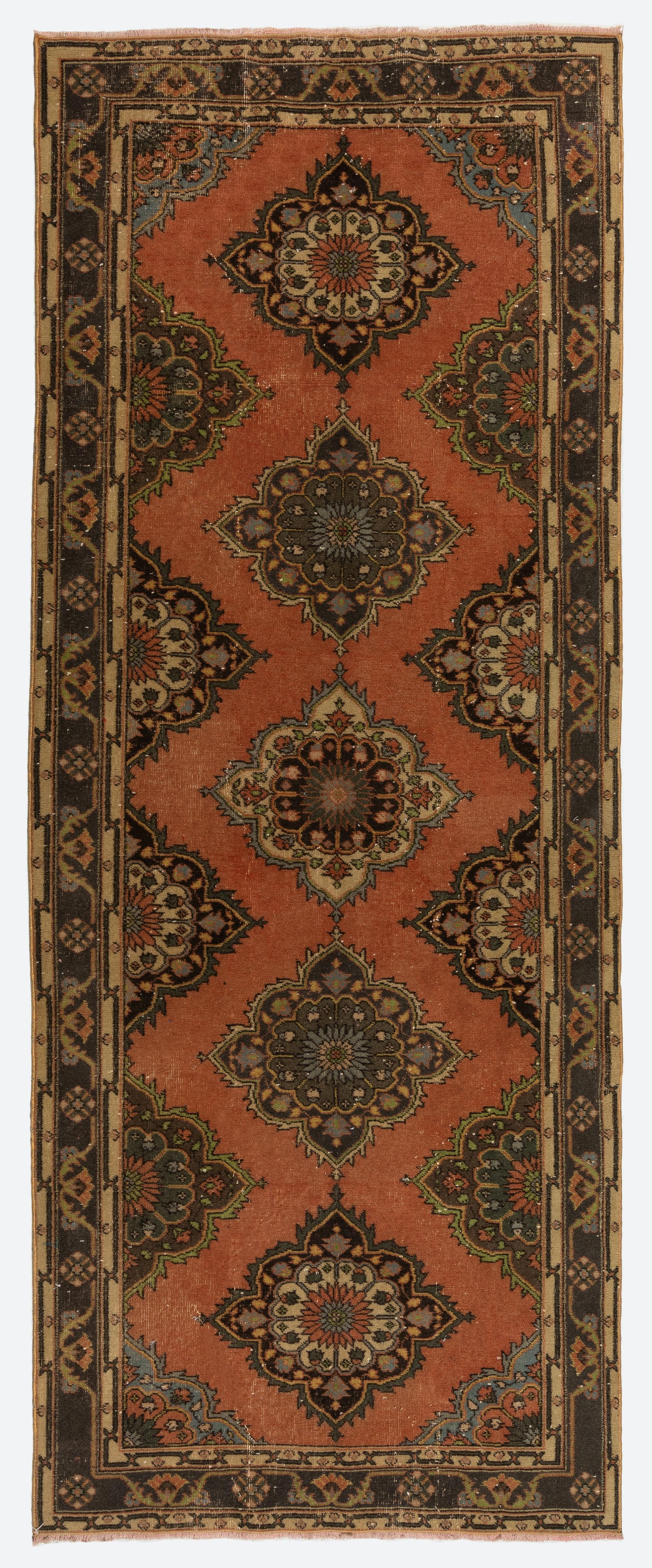 Un tappeto runner turco nei colori rosso, marrone e beige. È stato annodato a mano negli anni '60 con lana bassa su base di cotone e presenta un disegno a medaglioni multipli. È in ottime condizioni, lavato professionalmente, robusto e adatto ad