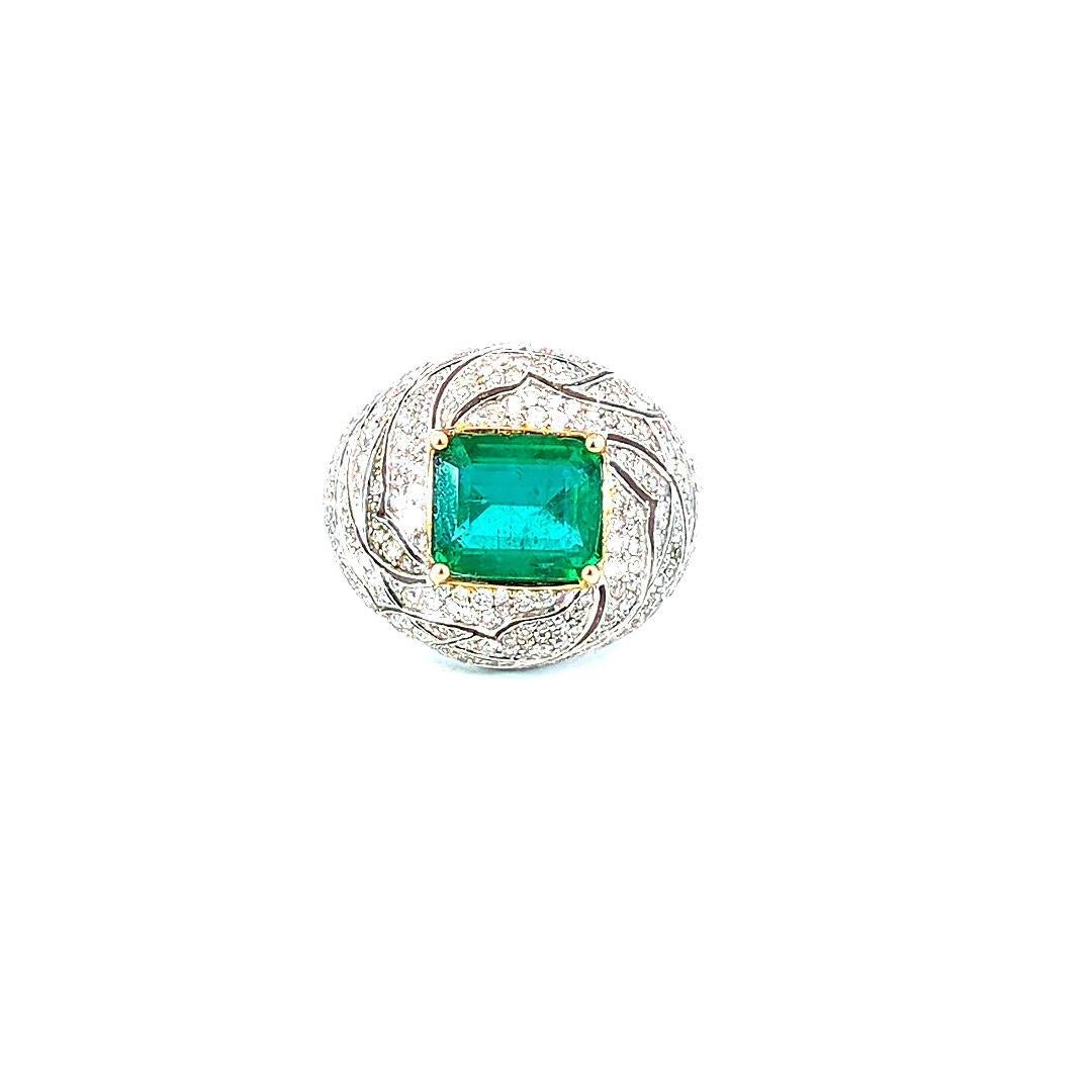 Dieser außergewöhnliche Smaragd- und Diamantring verkörpert zeitlose Eleganz und raffinierten Luxus. In seinem Zentrum liegt ein 4,8 Karat schwerer Smaragd im Quadratschliff, der in einem kräftigen Grünton leuchtet und eine beeindruckende Präsenz