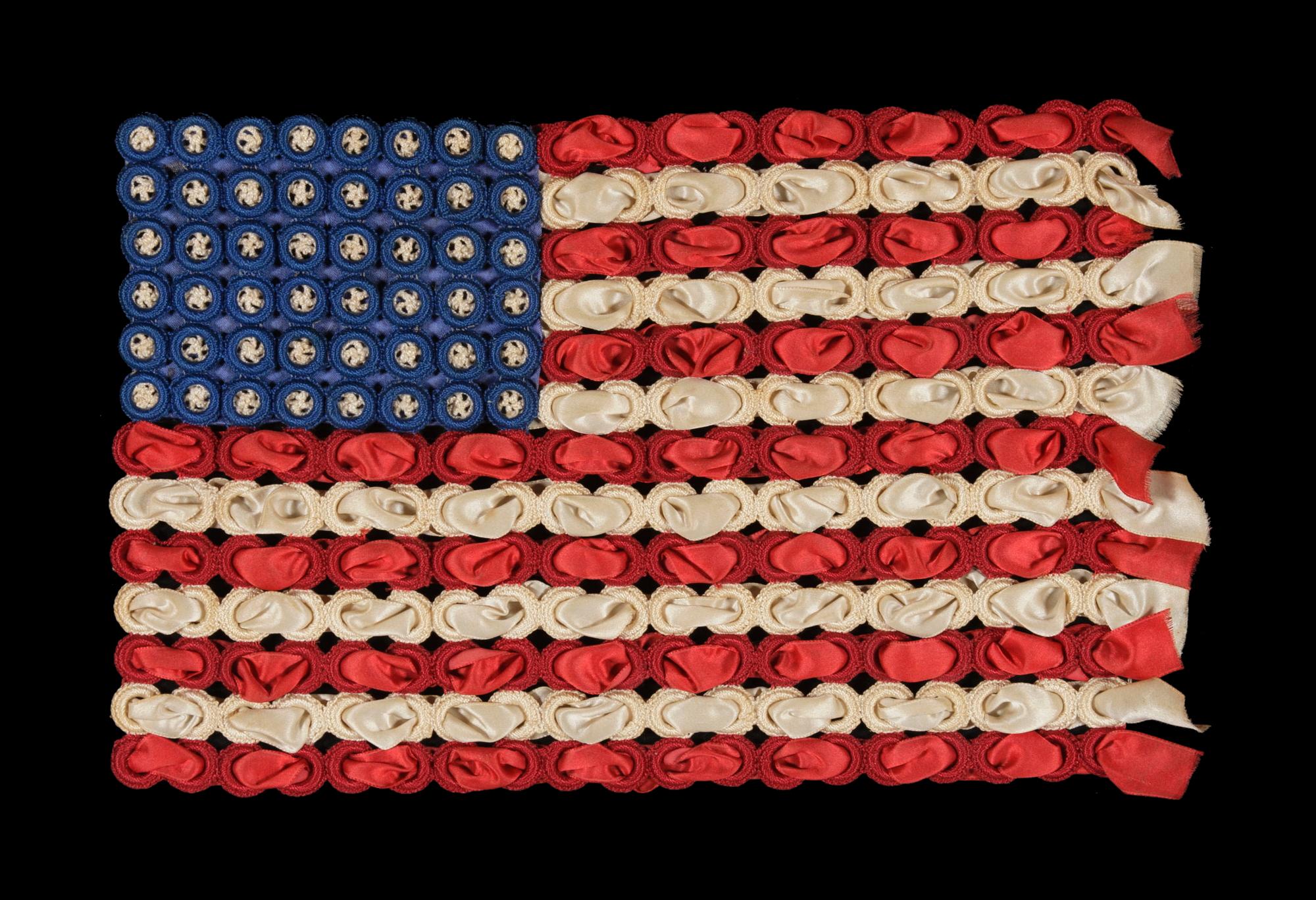 48 crocheted stars on a very graphic, three-dimensional flag made from silk ribbon and crocheted rings, WWI Era (U.S. involvement 1917-18)

Homemade, hand-constructed flags made from crocheted needlework, tatting, and/or various fabric and paper