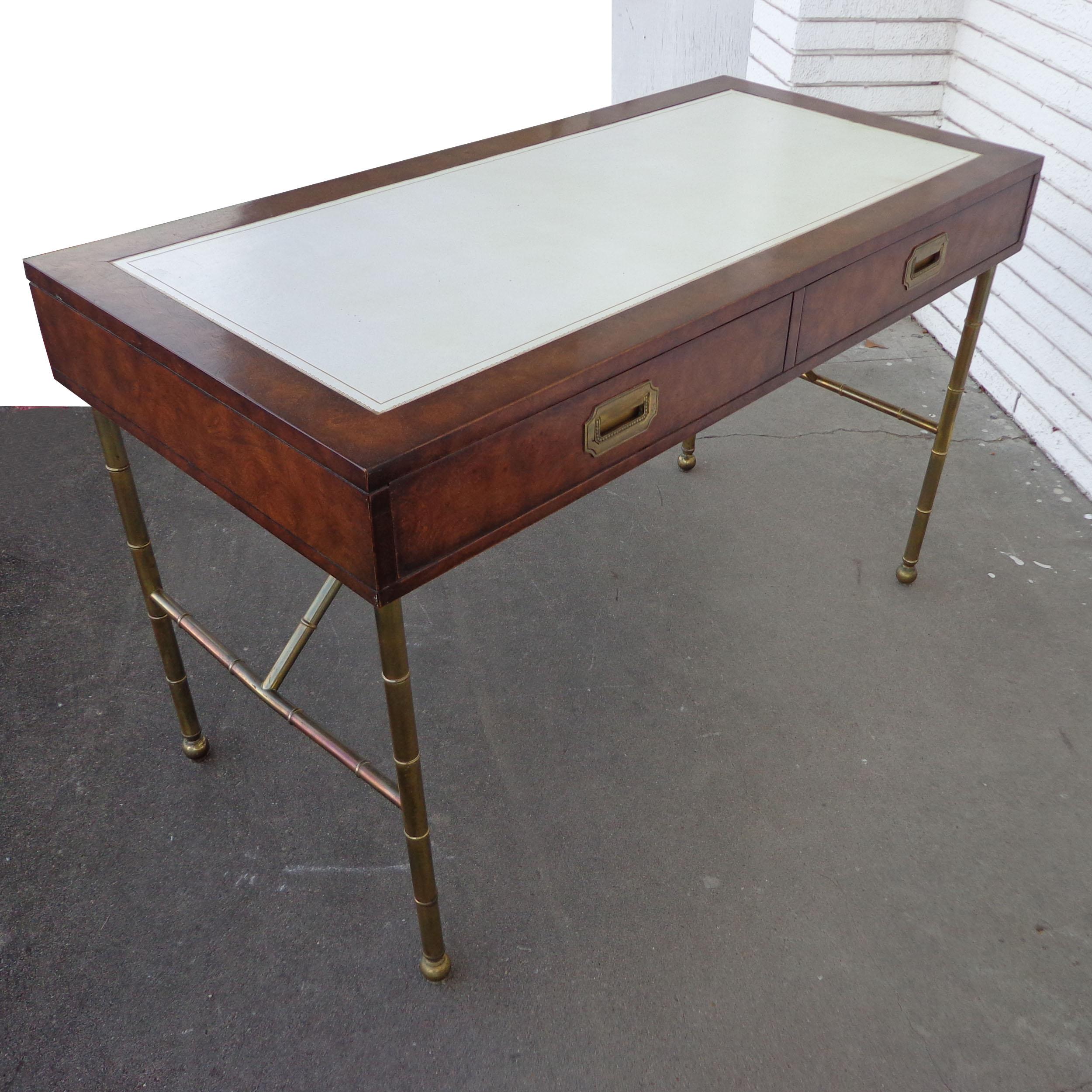 Mastercraft campaign writing desk

Beautiful burl case and brass faux bamboo legs. Two drawers with brass pulls. Top is a tooled off-white leather. Measure: 48